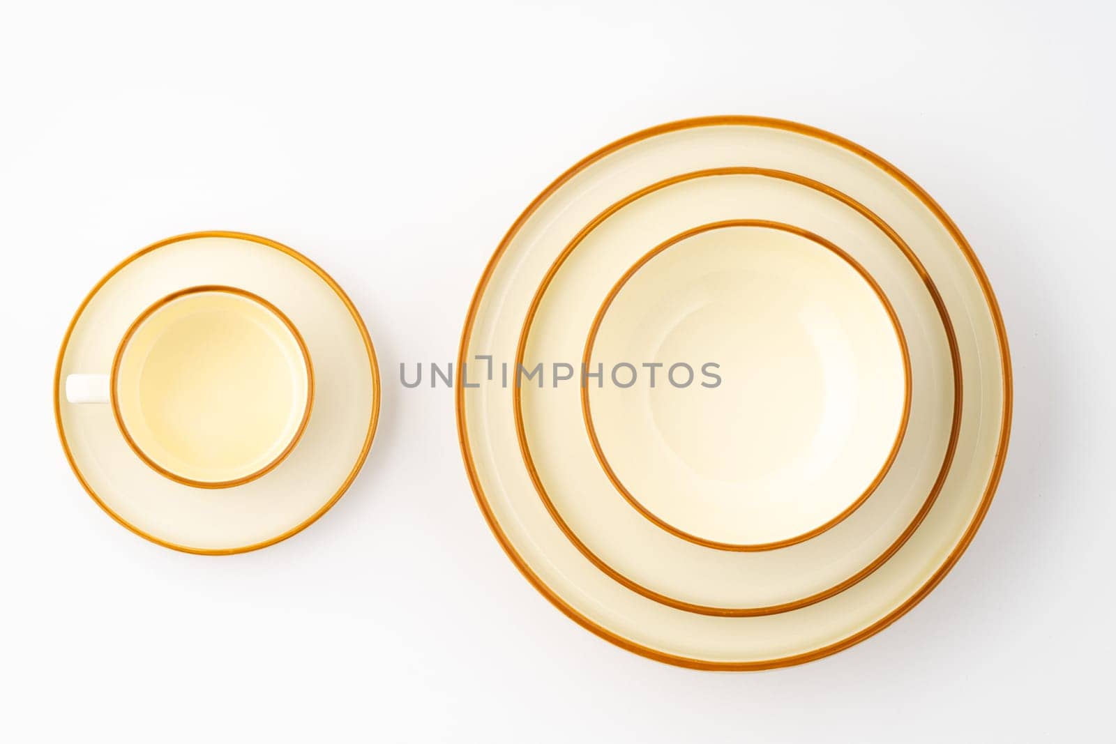 A set of white and brown ceramic plate and cup on a white background. Top view