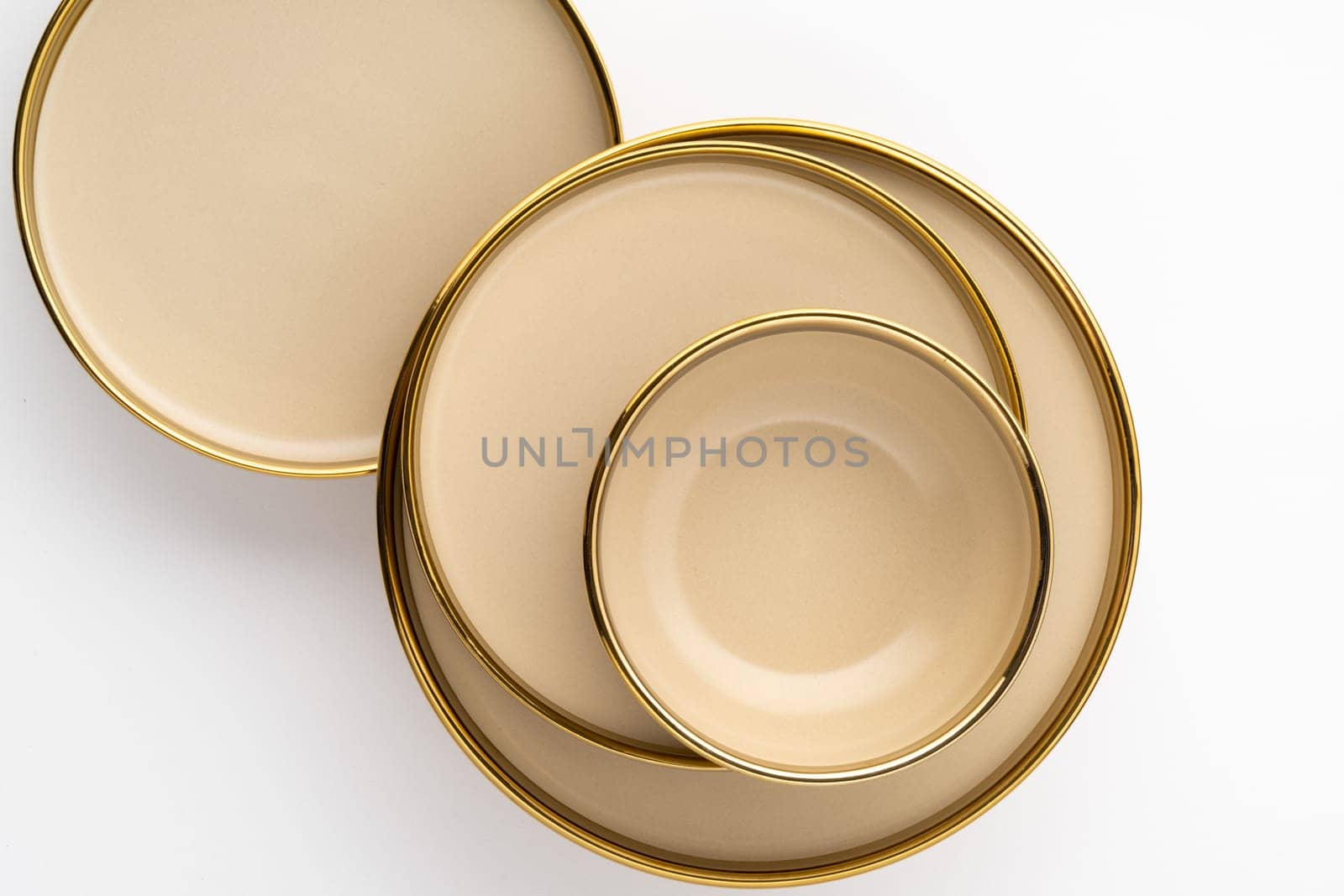 A set of light brown ceramic plate and bowl on a white background. Top view