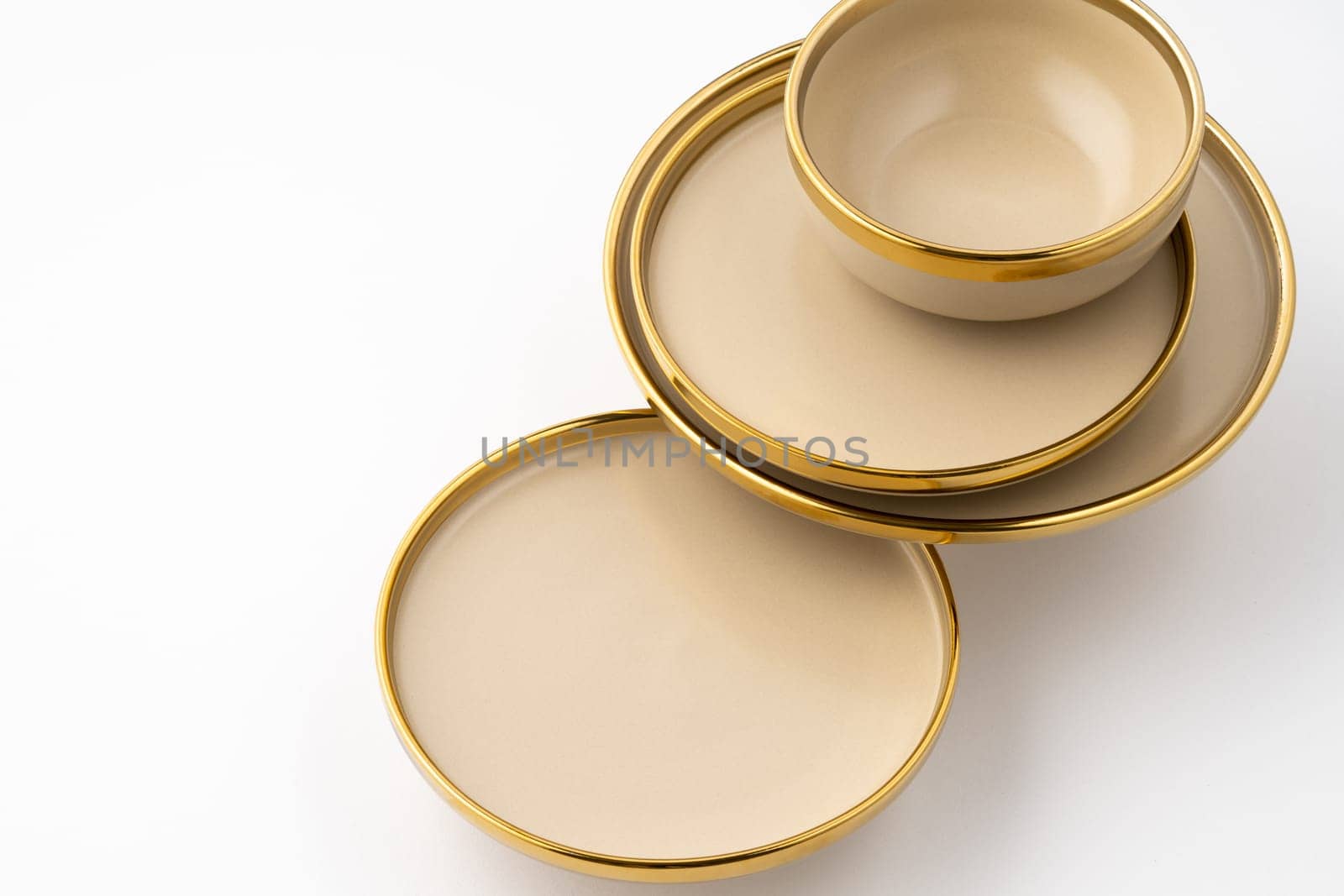 A set of light brown ceramic plate and bowl on a white background
