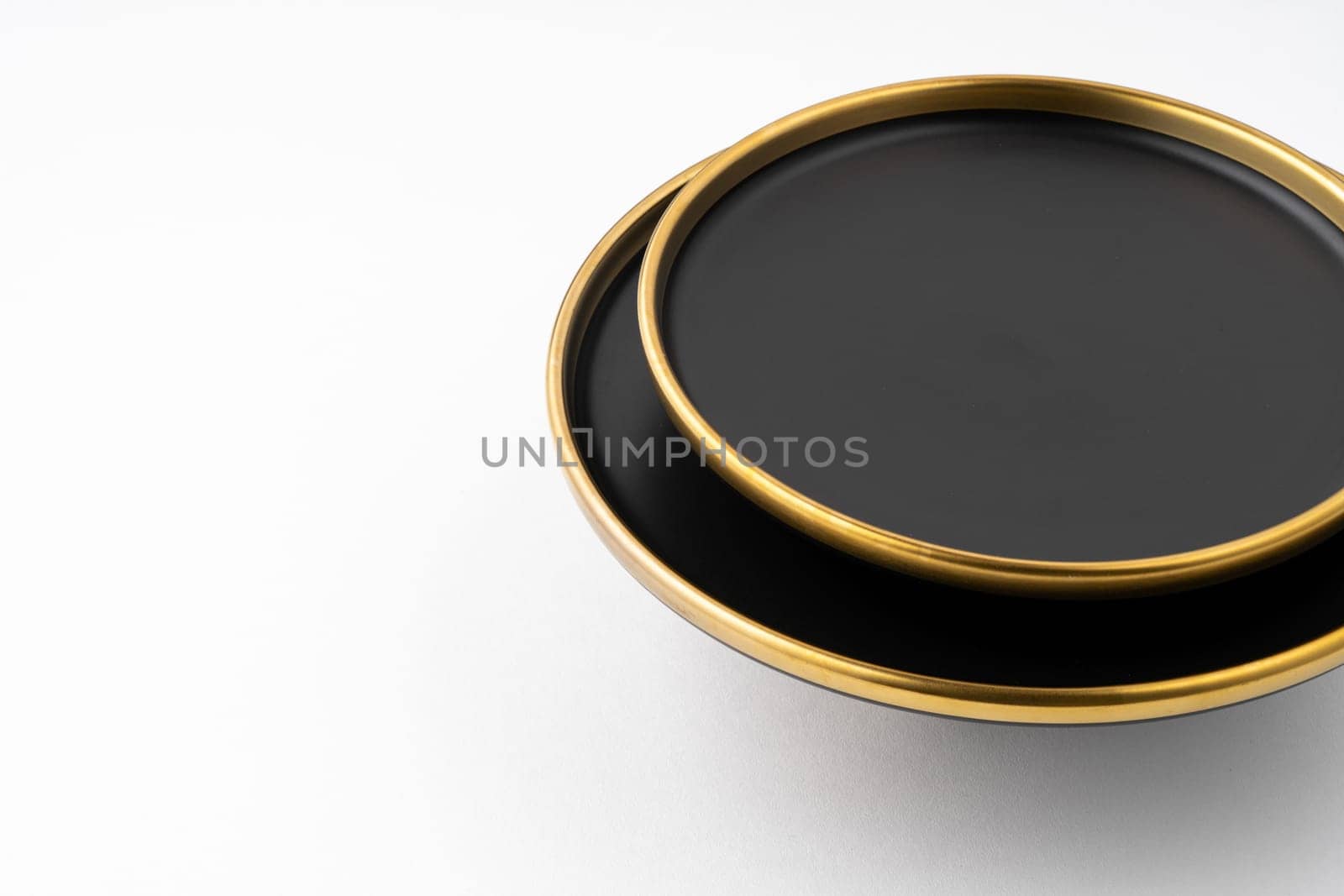 A set of black and golden ceramic plates on a white background