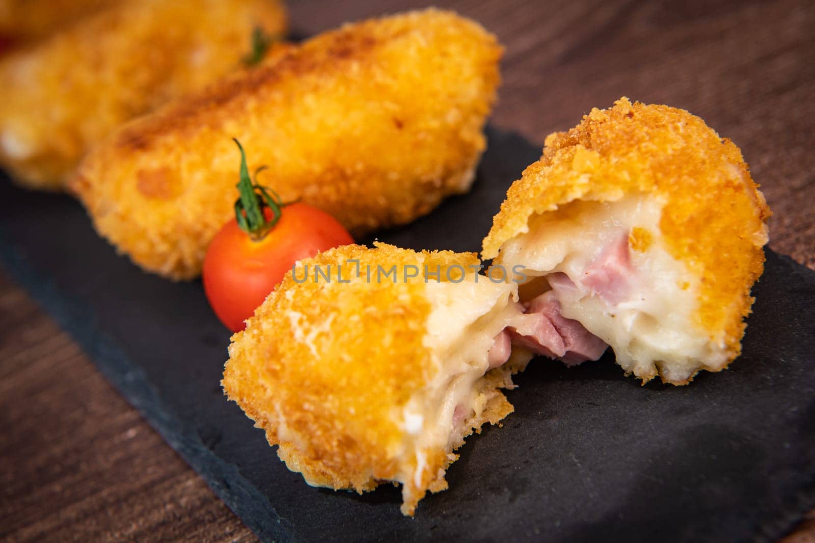 Homemade traditional Spanish croquettes or croquetas on a black plate with fork, Tapas food, High quality photo