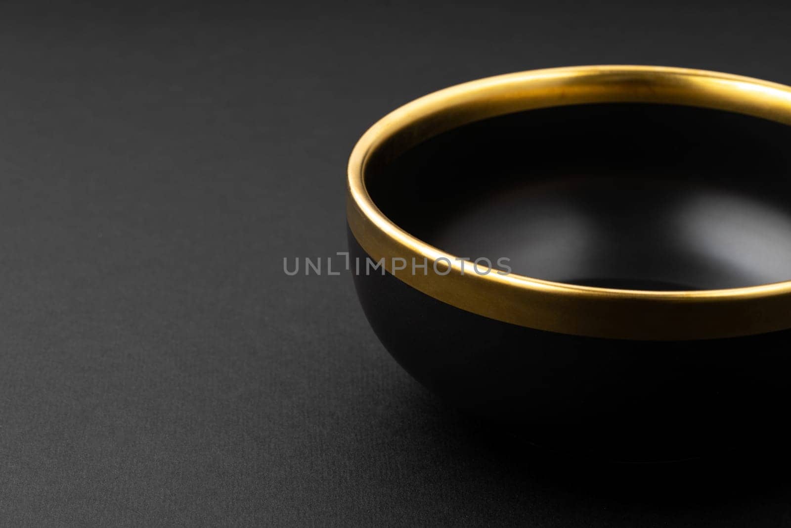 A set of black and golden ceramic plate on a black background