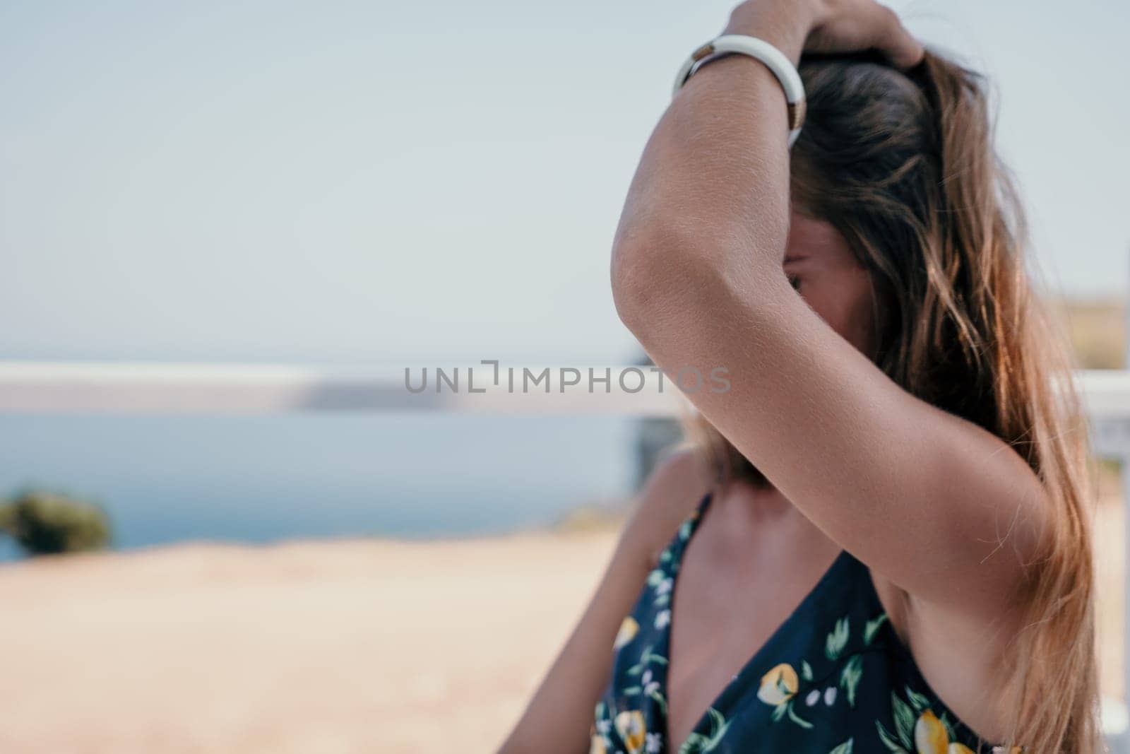 Happy woman portrait in cafe. Boho chic fashion style. Outdoor photo of young happy woman with long hair, sunny weather outdoors sitting in modern cafe. by panophotograph