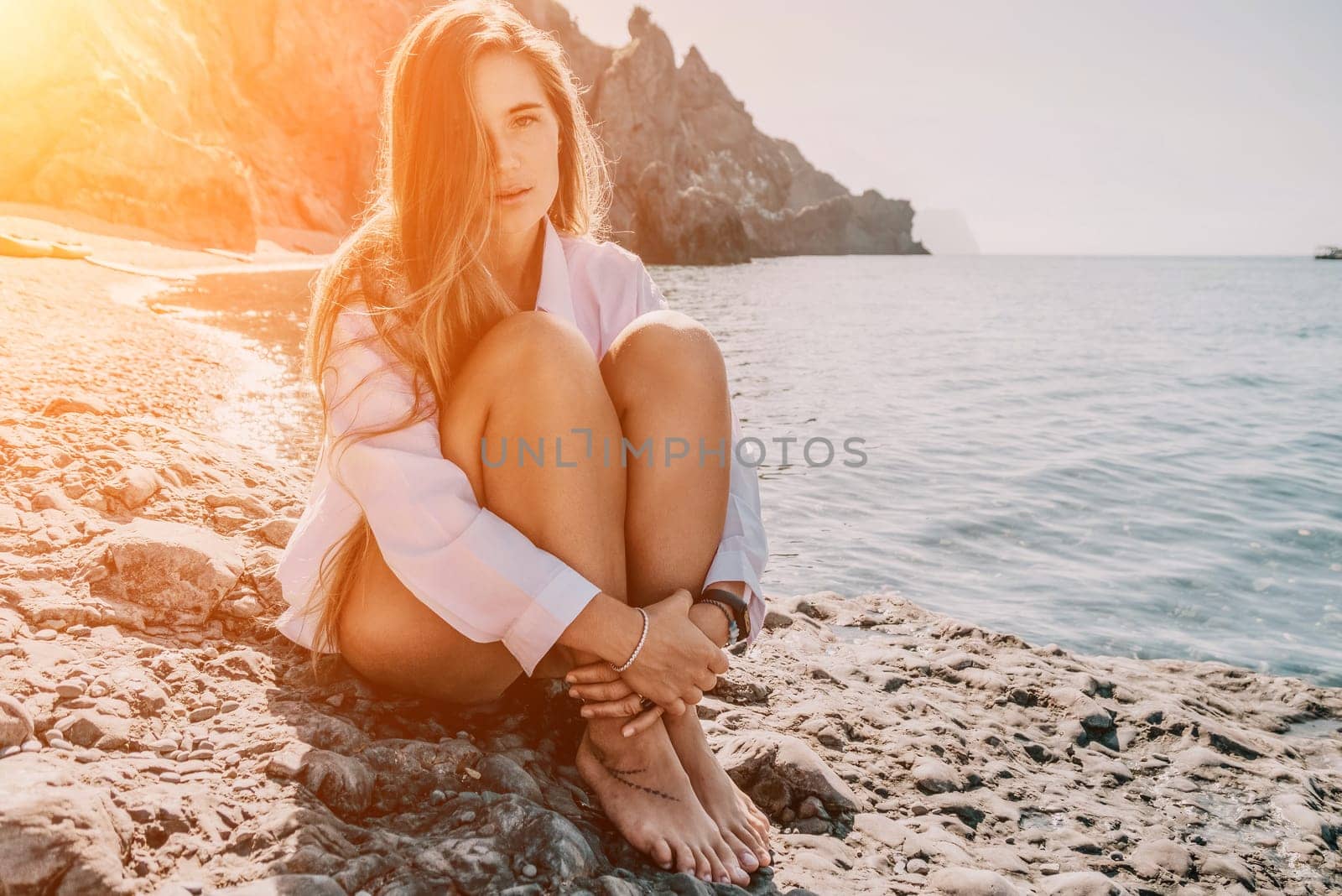 Young woman in red bikini on Beach. Girl lying on pebble beach and enjoying sun. Happy lady with long hair in bathing suit chilling and sunbathing by turquoise sea ocean on hot summer day. Close up by panophotograph