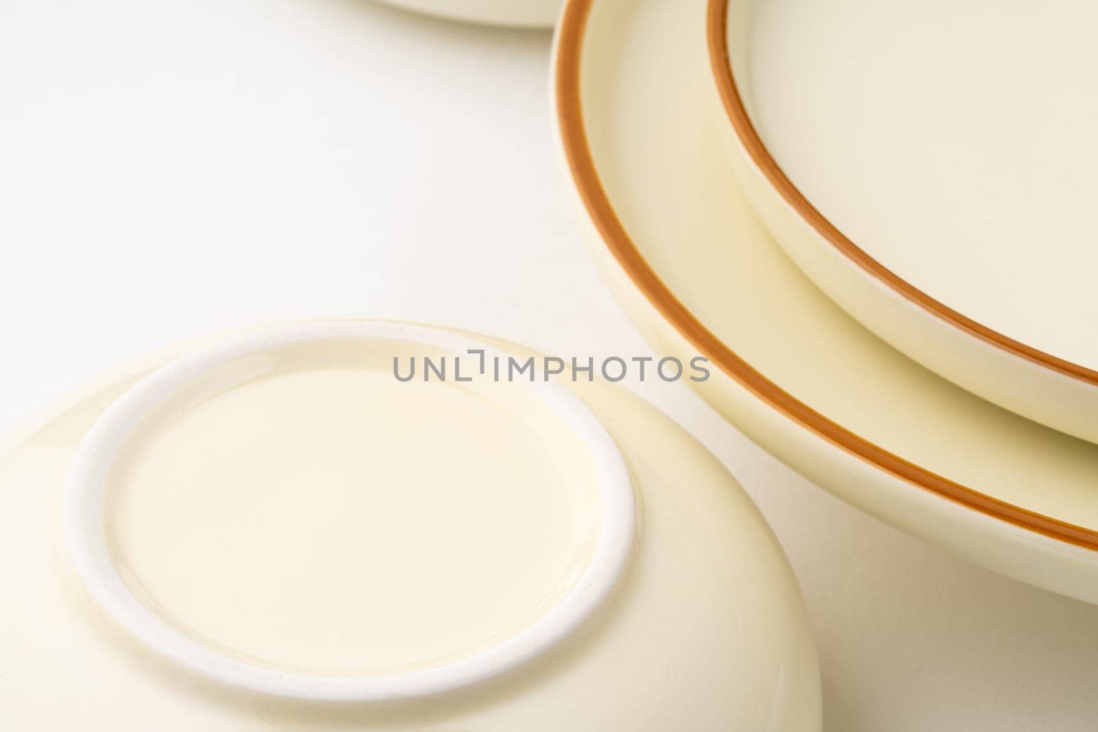 A set of white and brown ceramic plate and bowl on a white background. Close-up