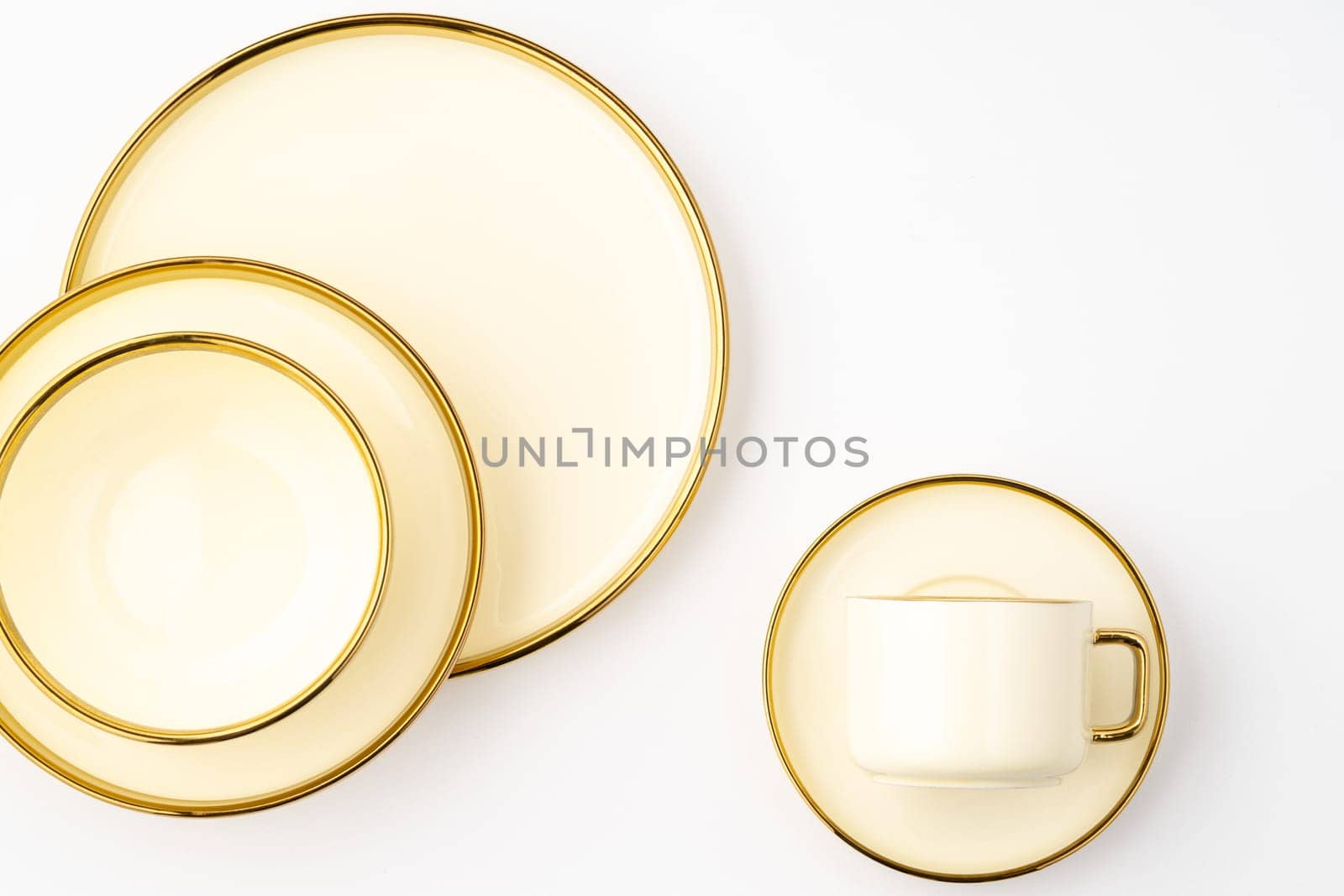 A top-view shot of golden luxury ceramic kitchen utensils on a white background