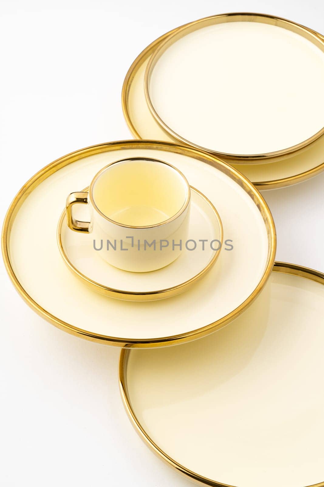 A set of golden luxury ceramic kitchen utensils on a white background