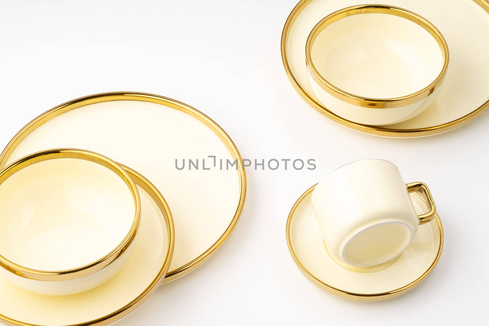 A set of golden luxury ceramic kitchen utensils on a white background