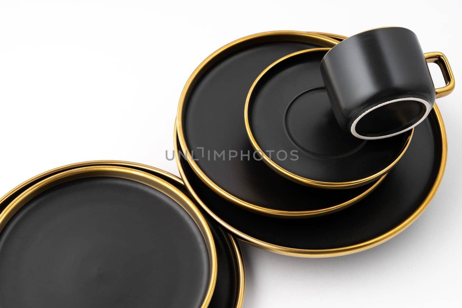A set of black and golden ceramic plates and cup on a white background by A_Karim