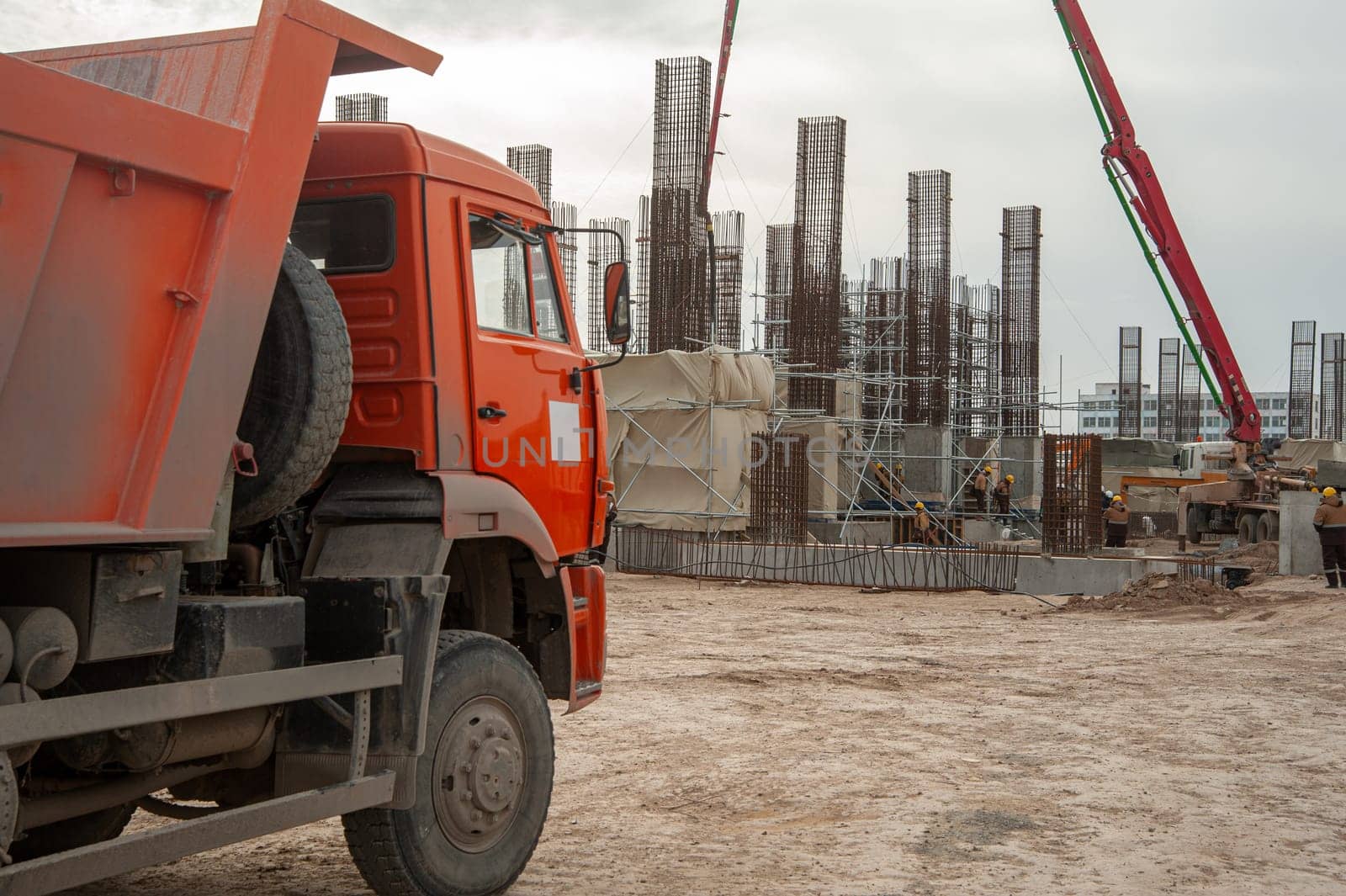 An orange dumper truck in an construction area