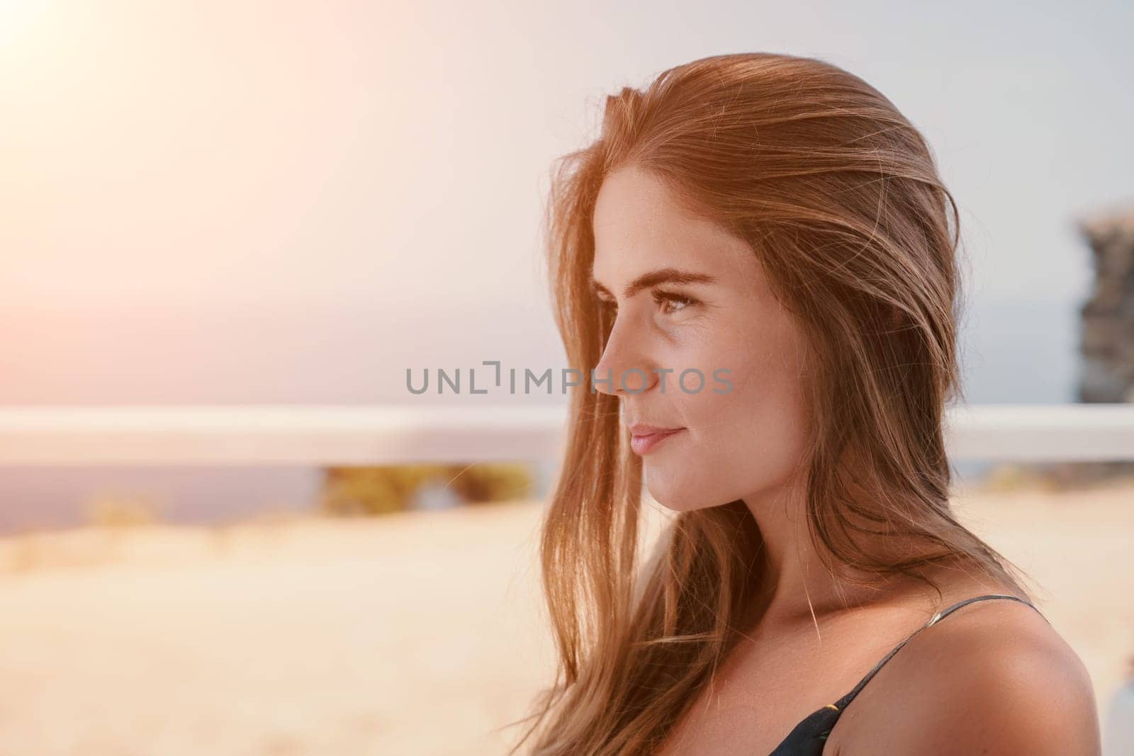 Happy woman portrait in cafe. Boho chic fashion style. Outdoor photo of young happy woman with long hair, sunny weather outdoors sitting in modern cafe. by panophotograph