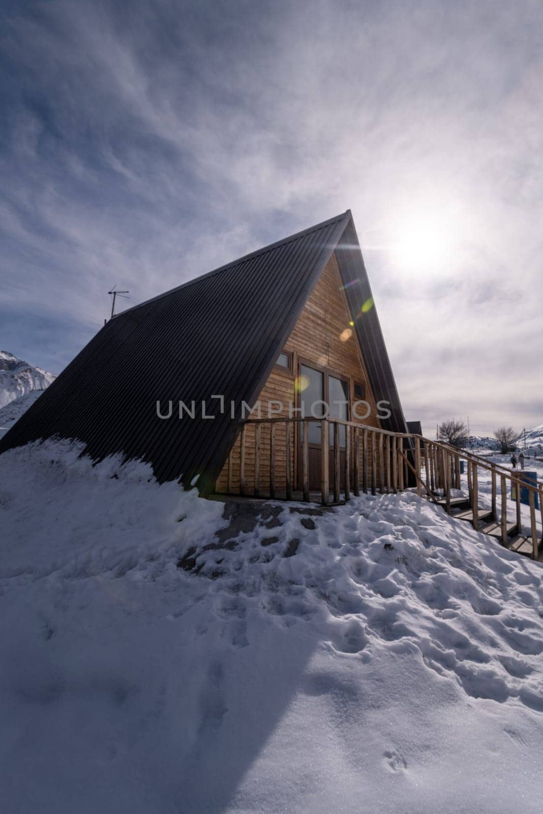 A vertical shot of a wooden cottage surrounded by snow. A recreation area in the mountains by A_Karim
