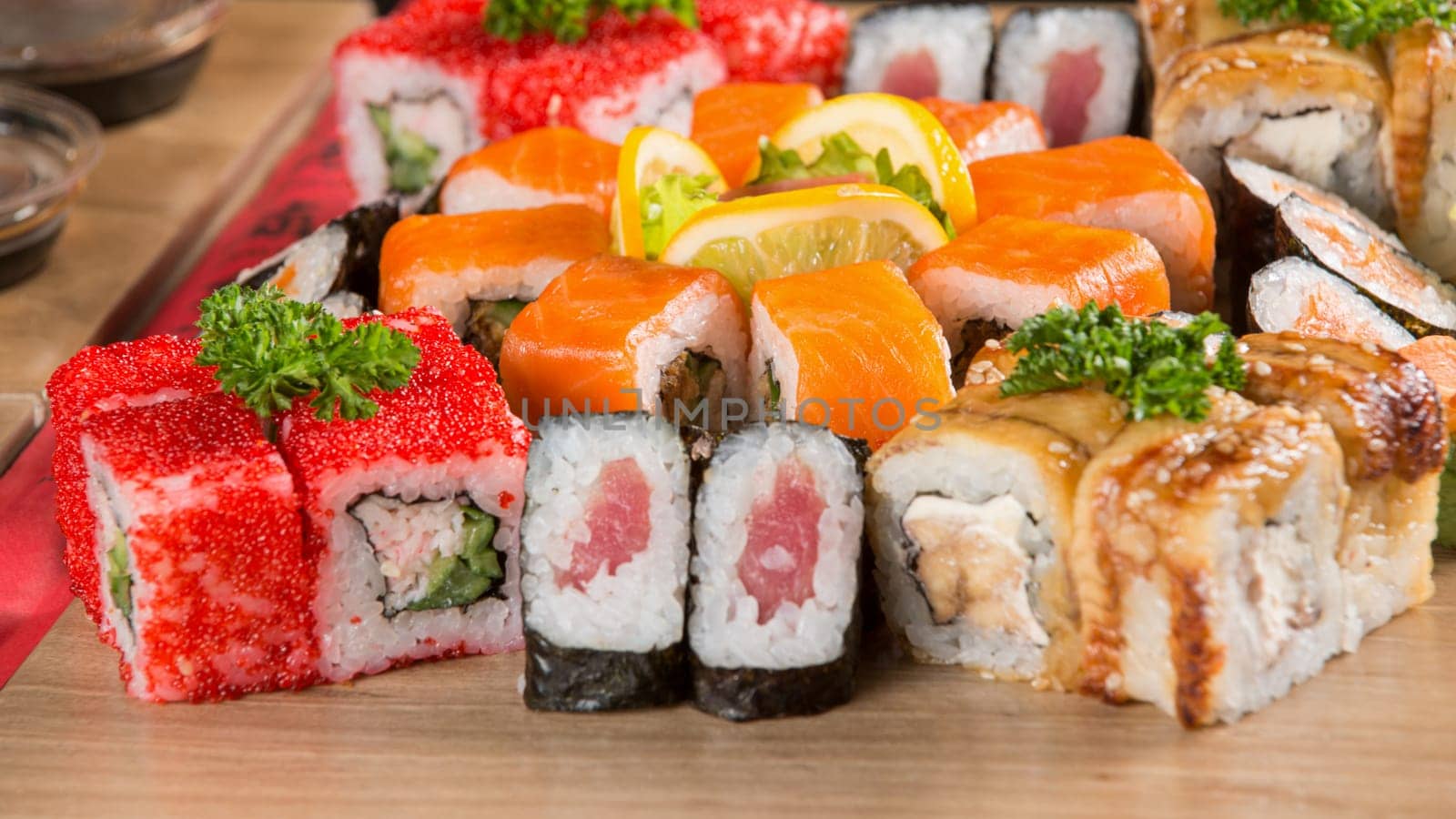 A closeup shot of a sushi set on a wooden plate by A_Karim