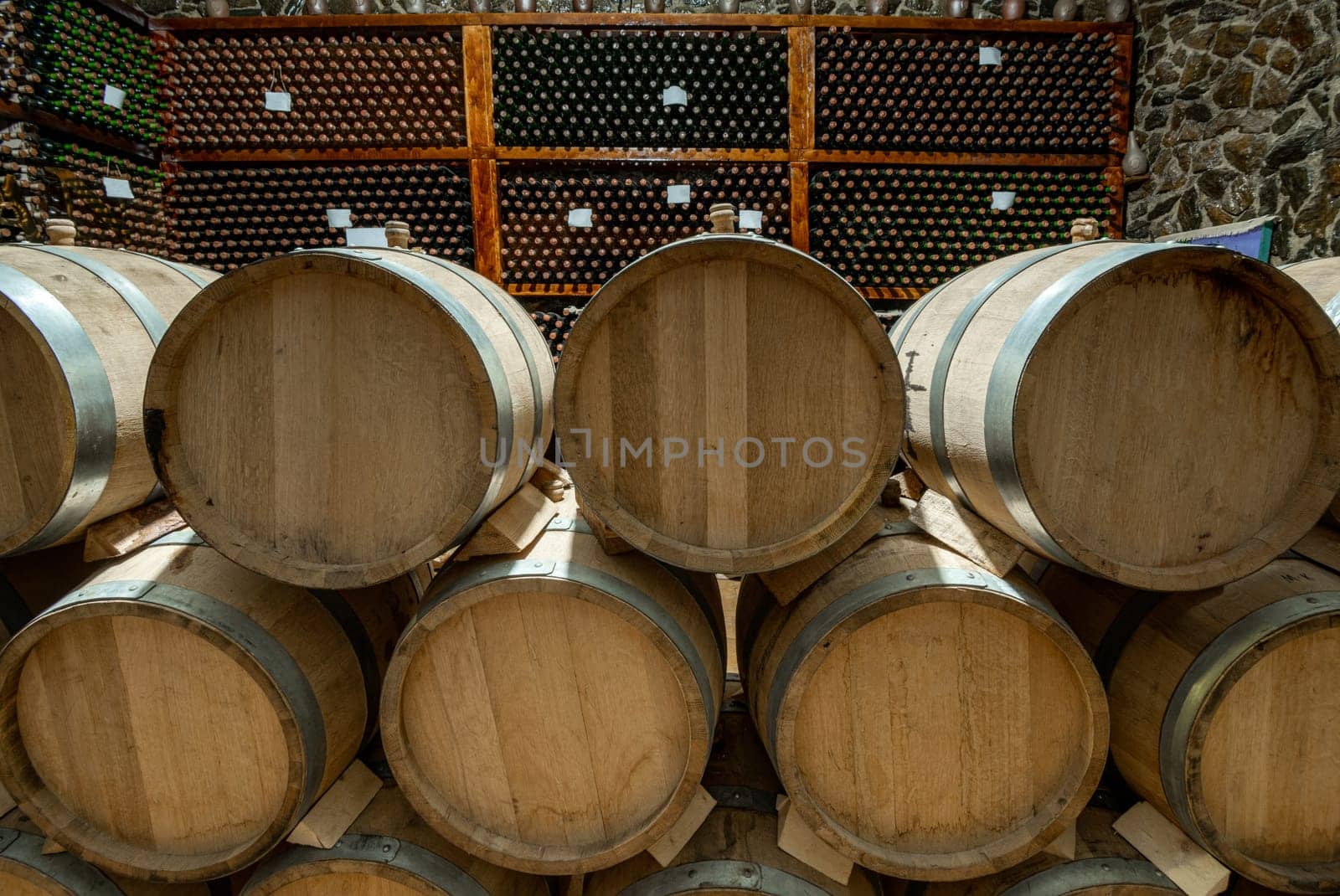 The wooden wine barrels with a wine cellar in the background by A_Karim