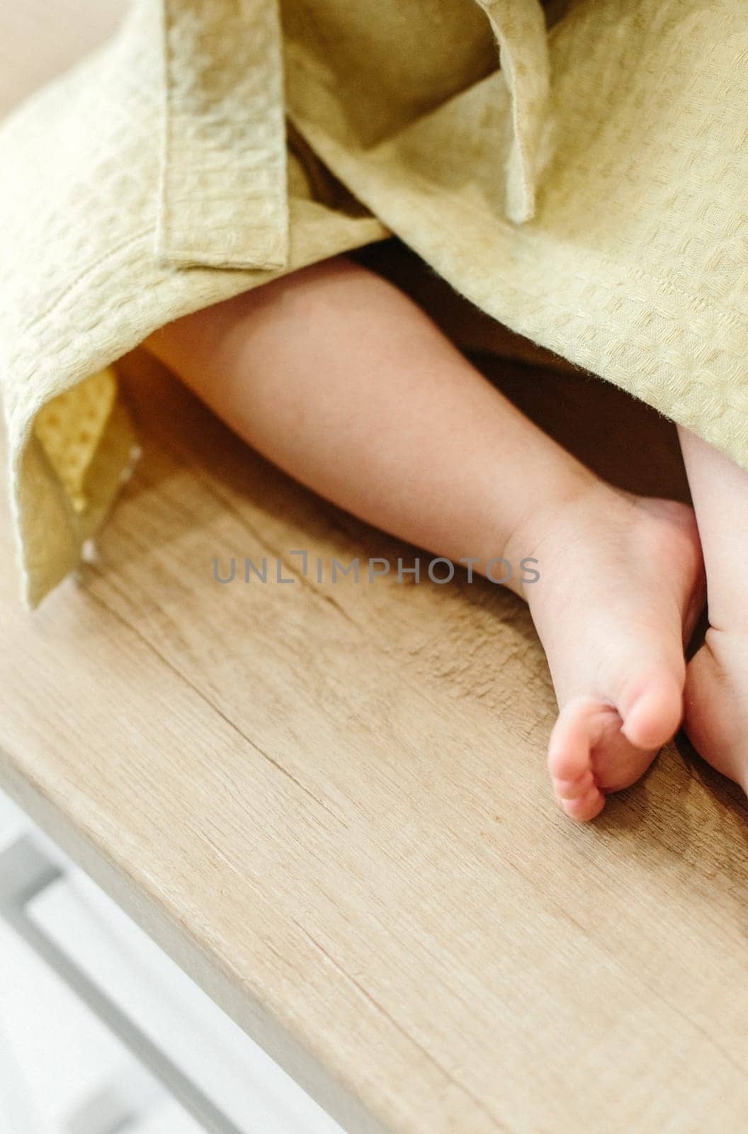The child sits on the windowsill in a dressing gown, close-up of the legs by Sd28DimoN_1976