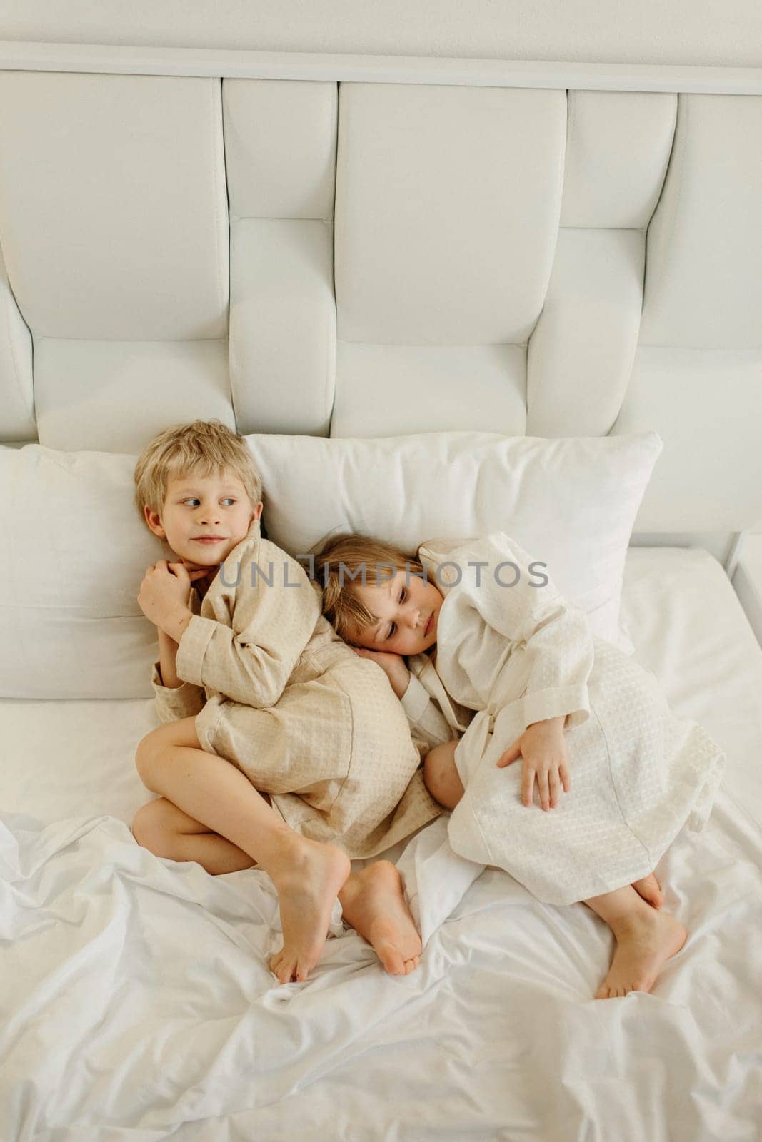 Brother and sister lying on the bed in bathrobes after a shower by Sd28DimoN_1976