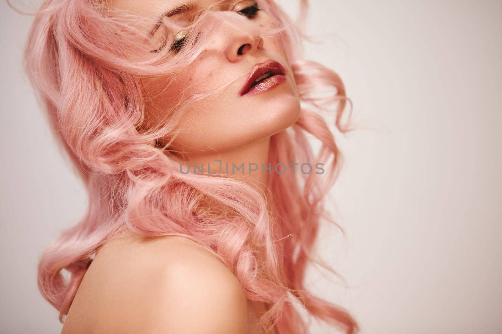 Soft-Girl Style with Trend Pink Flying Hair, Fashion Make-up. Woman Face with Fake Freckles and Rose Flowers. Blonde Female Model with perfect Fresh Clean Skin, Blush Rouge