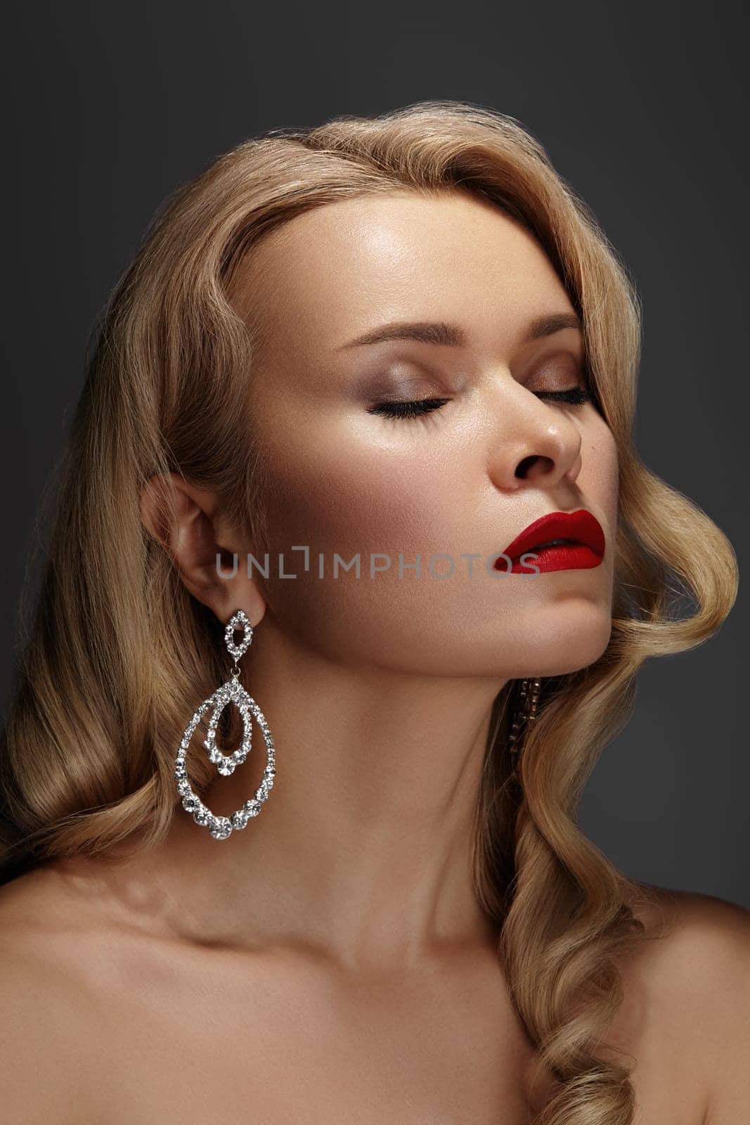 Beautiful Sexy Woman with Fashion Make-up and Blond Curly Wave Hairstyle, Bright Accessories. Glamour Pin-up Girl with Red lips. American Diva Style with Brilliant Earrings and Rings