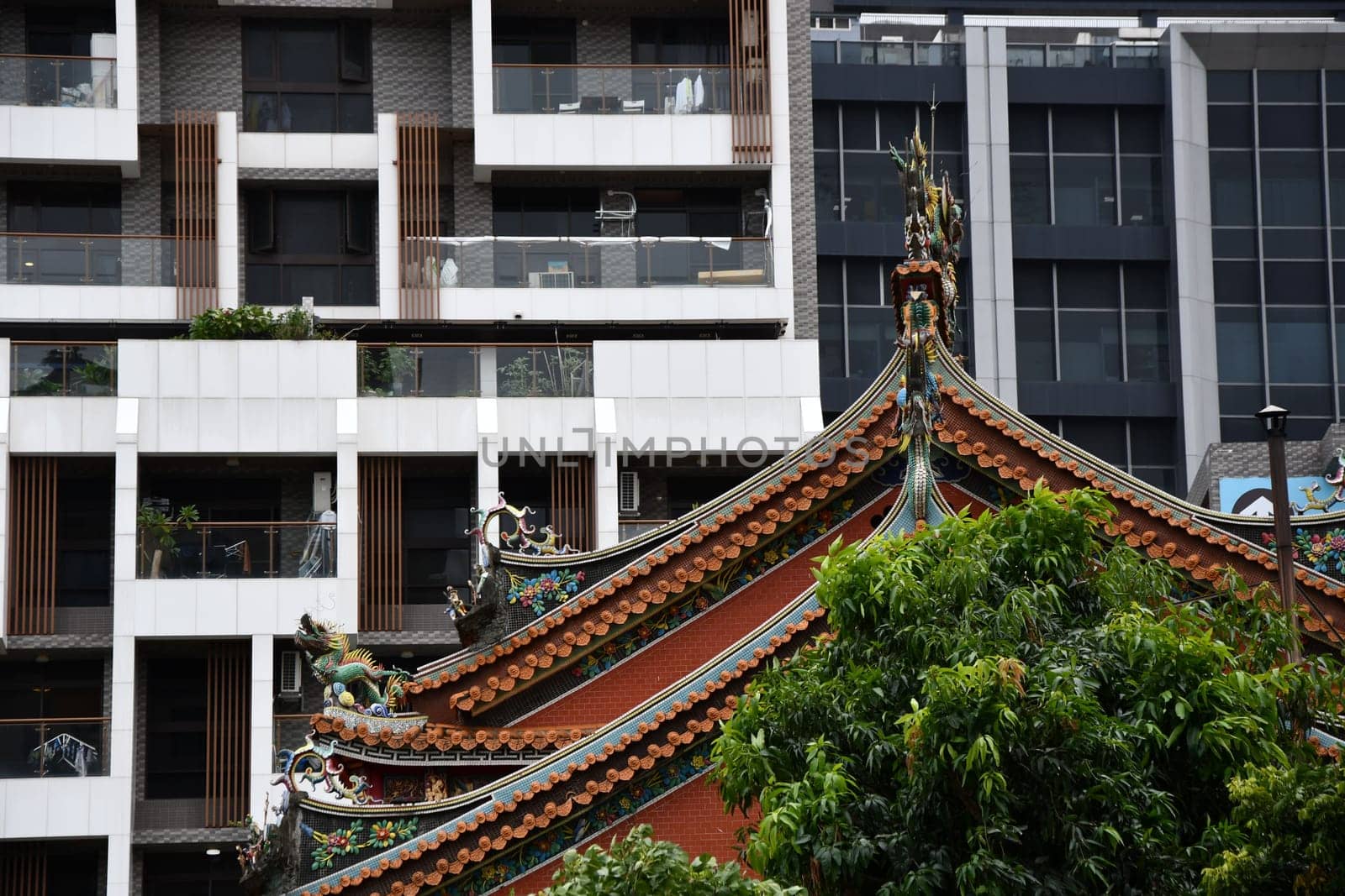 View of a roof of a historic temple in front of a modern building in Taipei, Taiwan