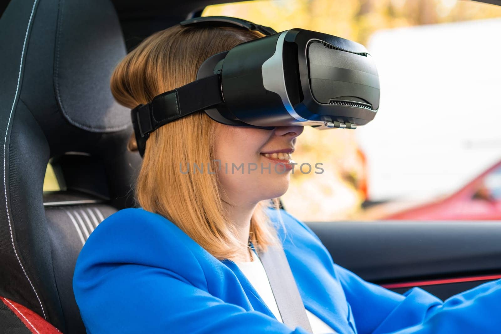 Business woman in the VR googles sitting in the car and turning the steering wheel in a car by vladimka