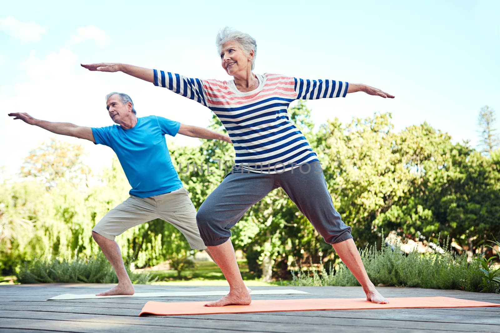Yoga poses for yogis of all ages. a senior couple doing yoga together outdoors