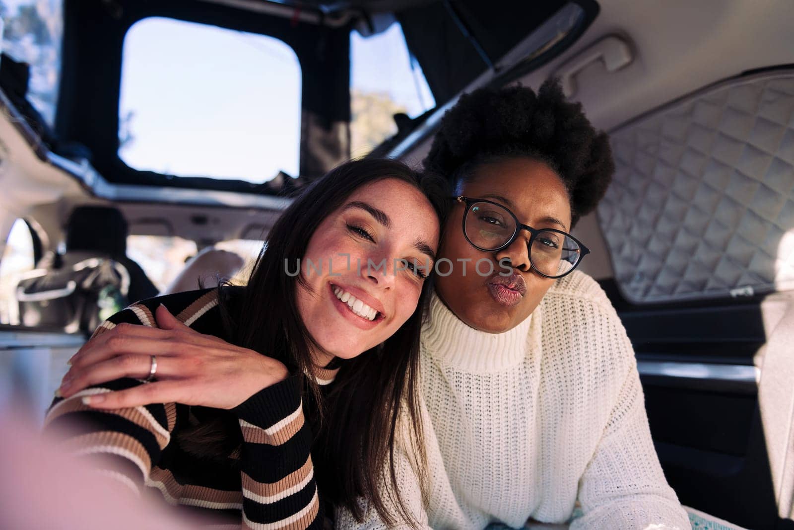 adventurous friends capturing happy moments in a camper van, concept of weekend getaway with best friend and road trip adventure