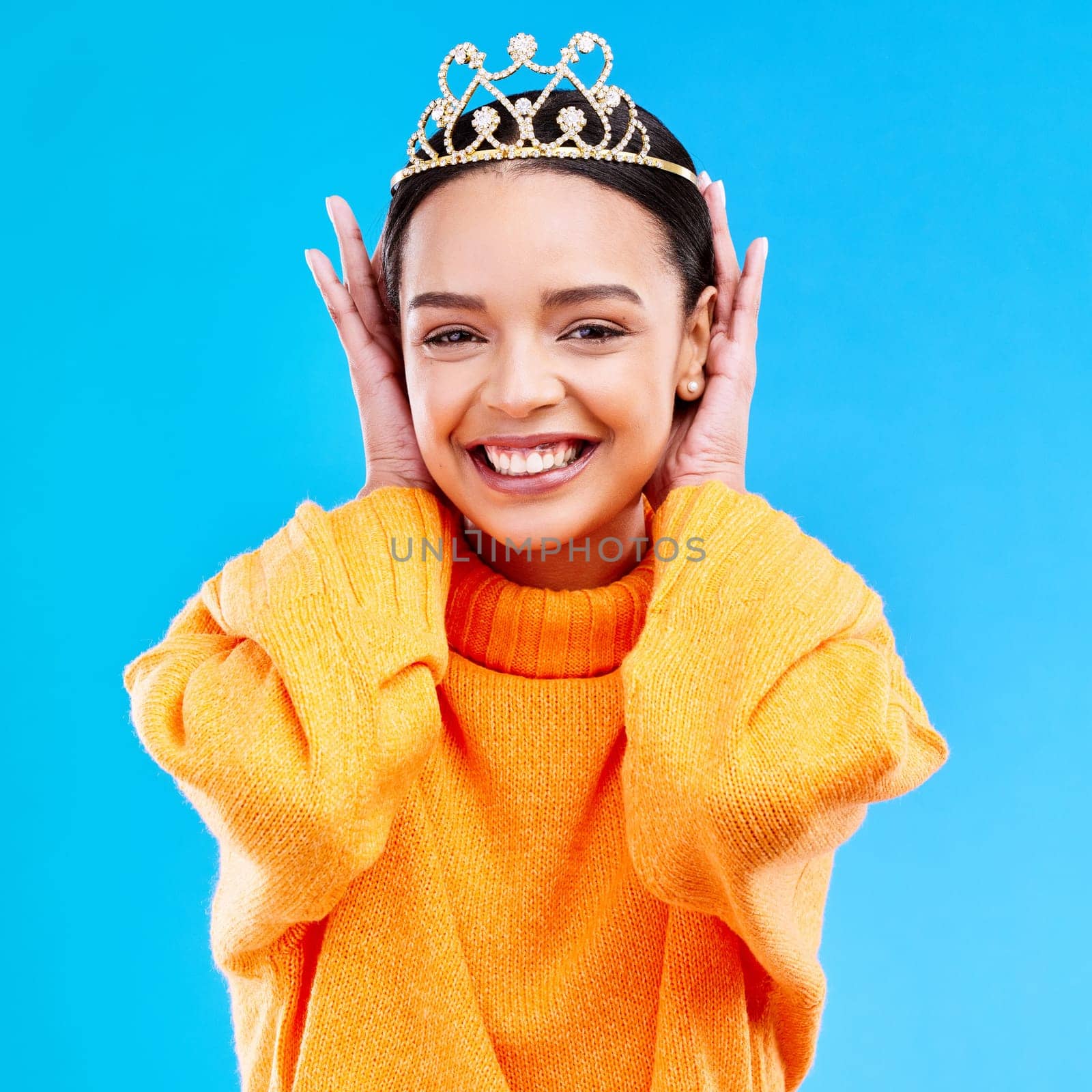 Excited, crown and portrait of woman in studio for celebration, princess and party. Smile, beauty and fashion with female and tiara on blue background for achievement, winner and prom event by YuriArcurs