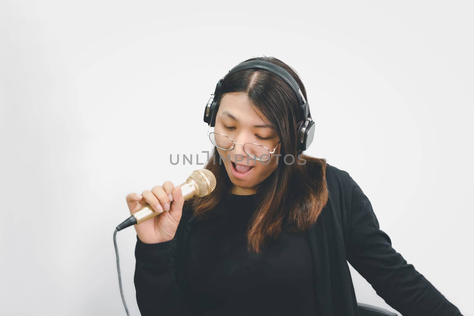 Beautiful asian woman (LGBTQ) is a singer. She enjoying sing a song or karaoke in music studio with microphone condenser and headphones for fun or voice creative