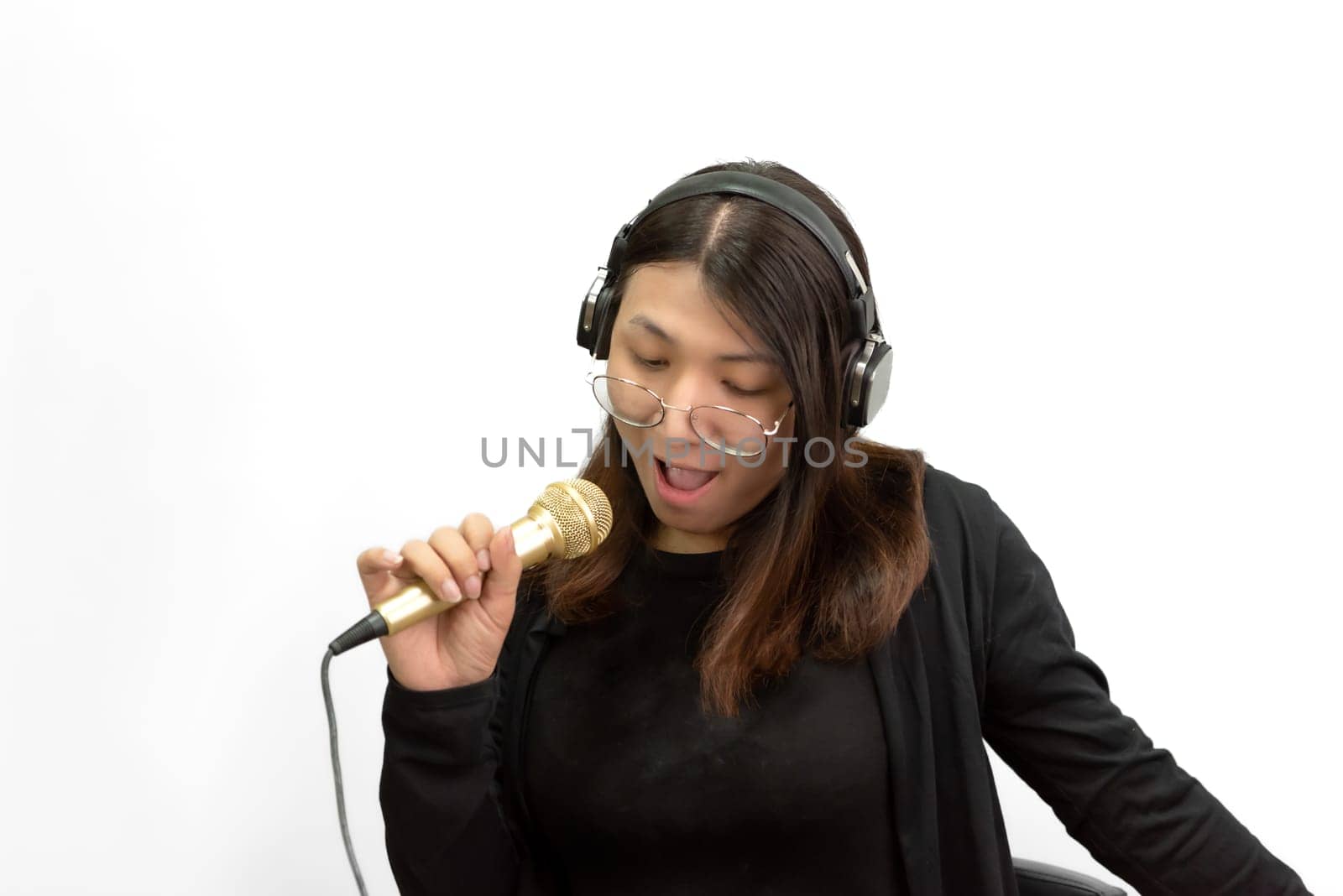 Beautiful asian woman (LGBTQ) is a singer. She enjoying sing a song or karaoke in music studio with microphone condenser and headphones for fun or voice creative