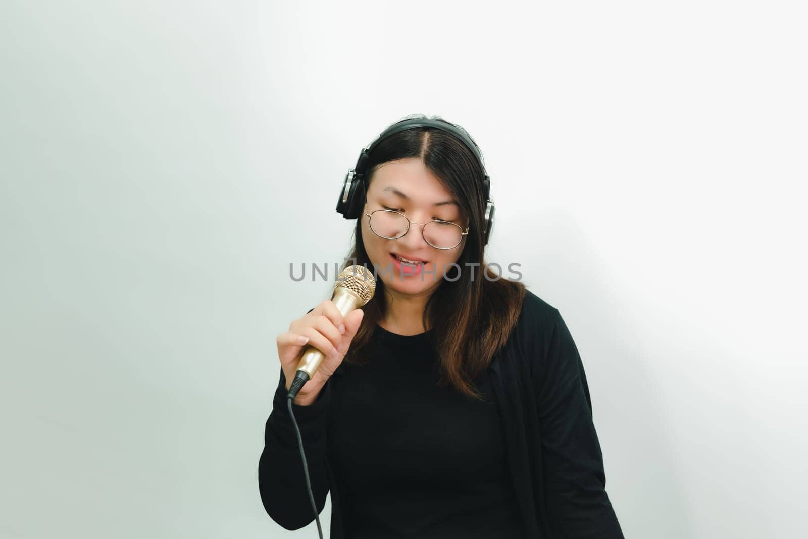 Beautiful asian woman (LGBTQ) is a singer. She enjoying sing a song or karaoke in music studio with microphone condenser and headphones for fun or voice creative