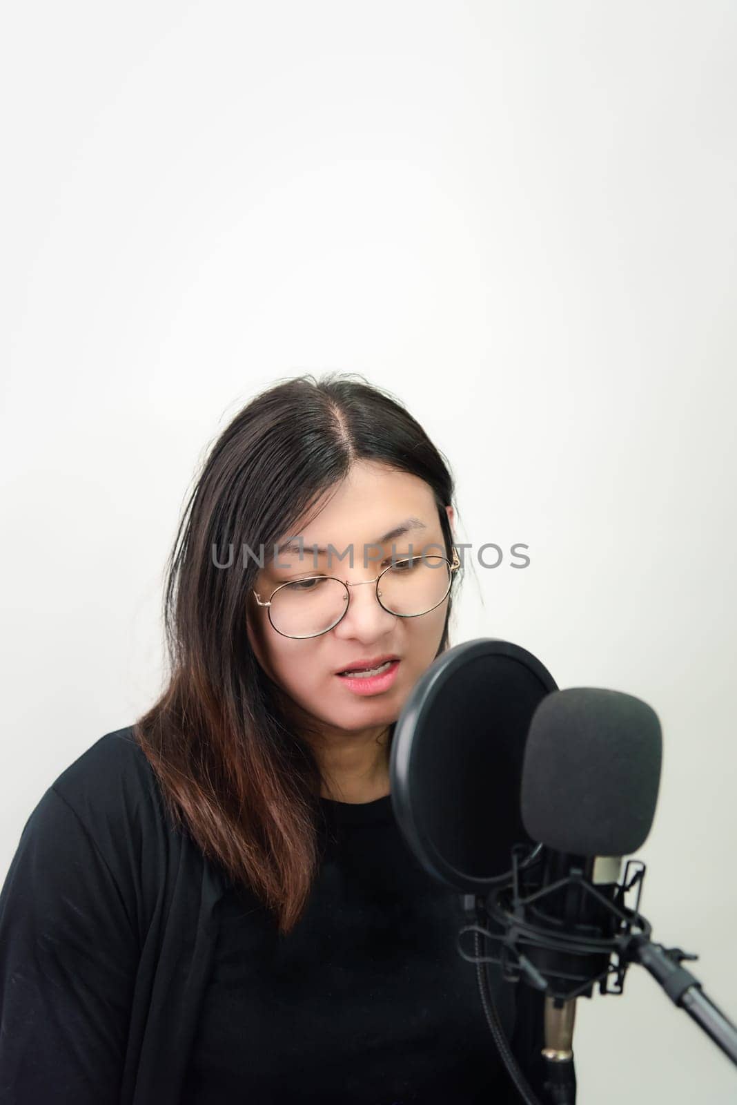 Beautiful asian woman (LGBTQ) is a singer. She enjoying sing a song or karaoke in music studio with microphone condenser and headphones for fun or voice creative