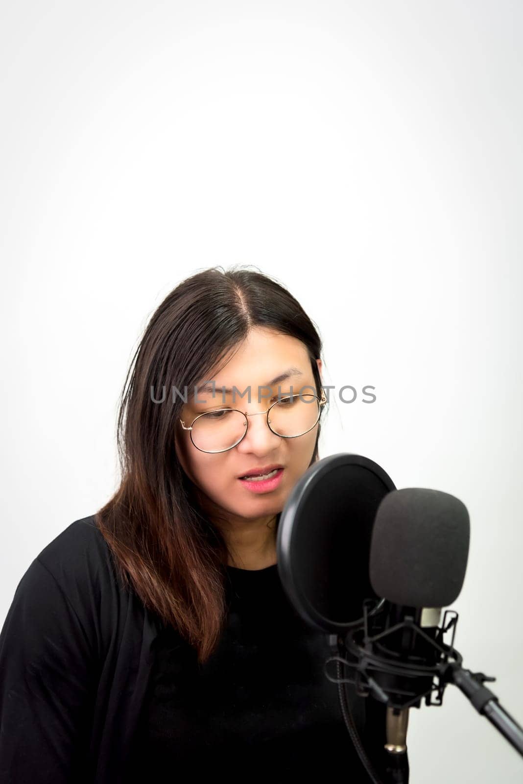 Beautiful asian woman (LGBTQ) is a singer. She enjoying sing a song or karaoke in music studio with microphone condenser and headphones for fun or voice creative