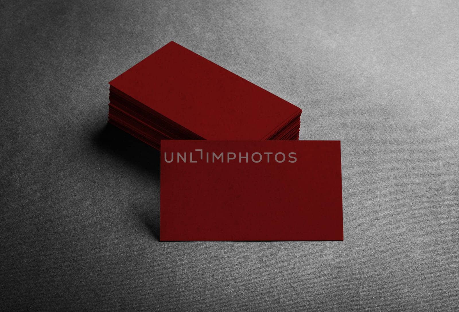 Stack of blank dark red business card on grey textured background top view. Identify design, corporate templates.