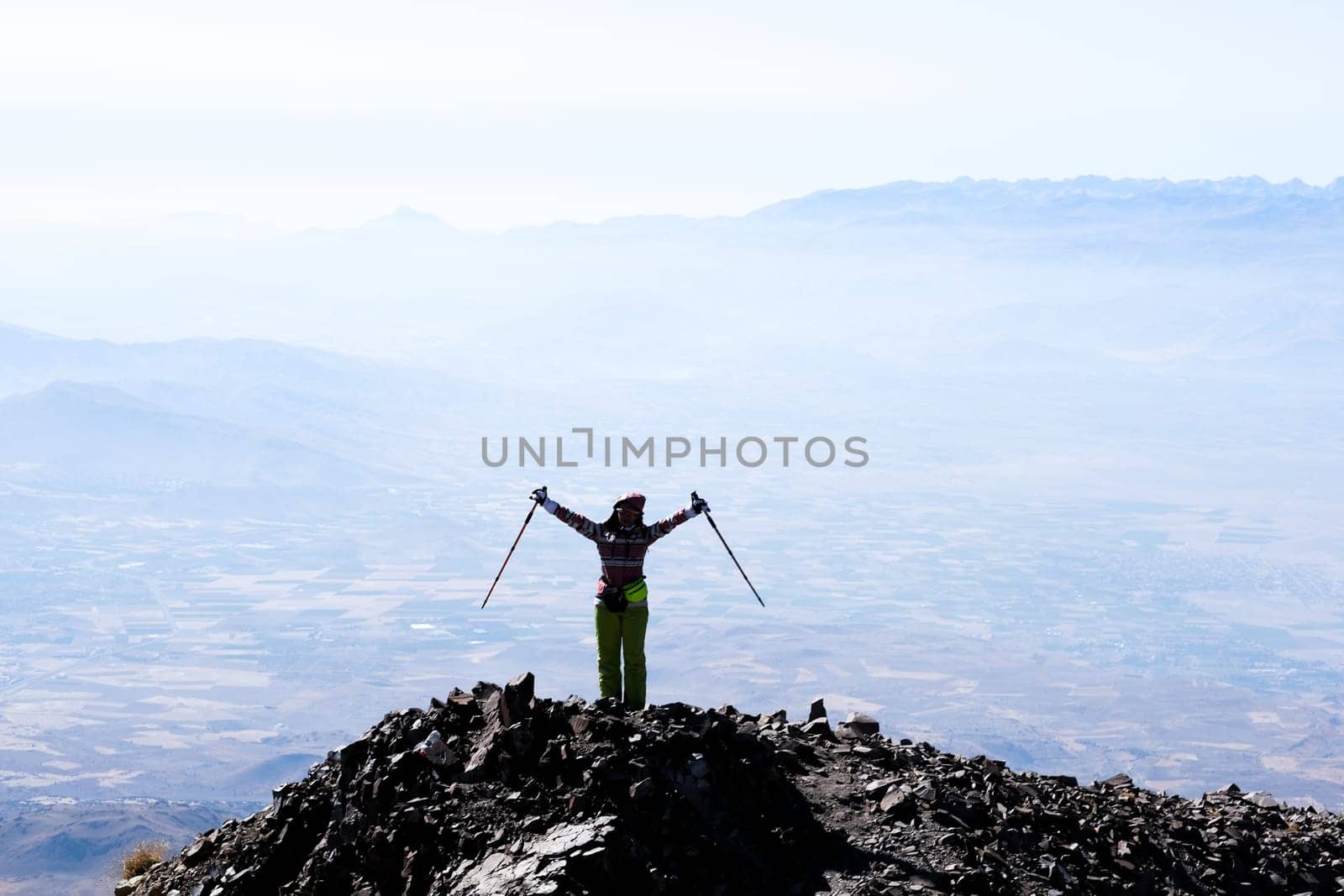 Tourist on mountain top with raised hands by GekaSkr