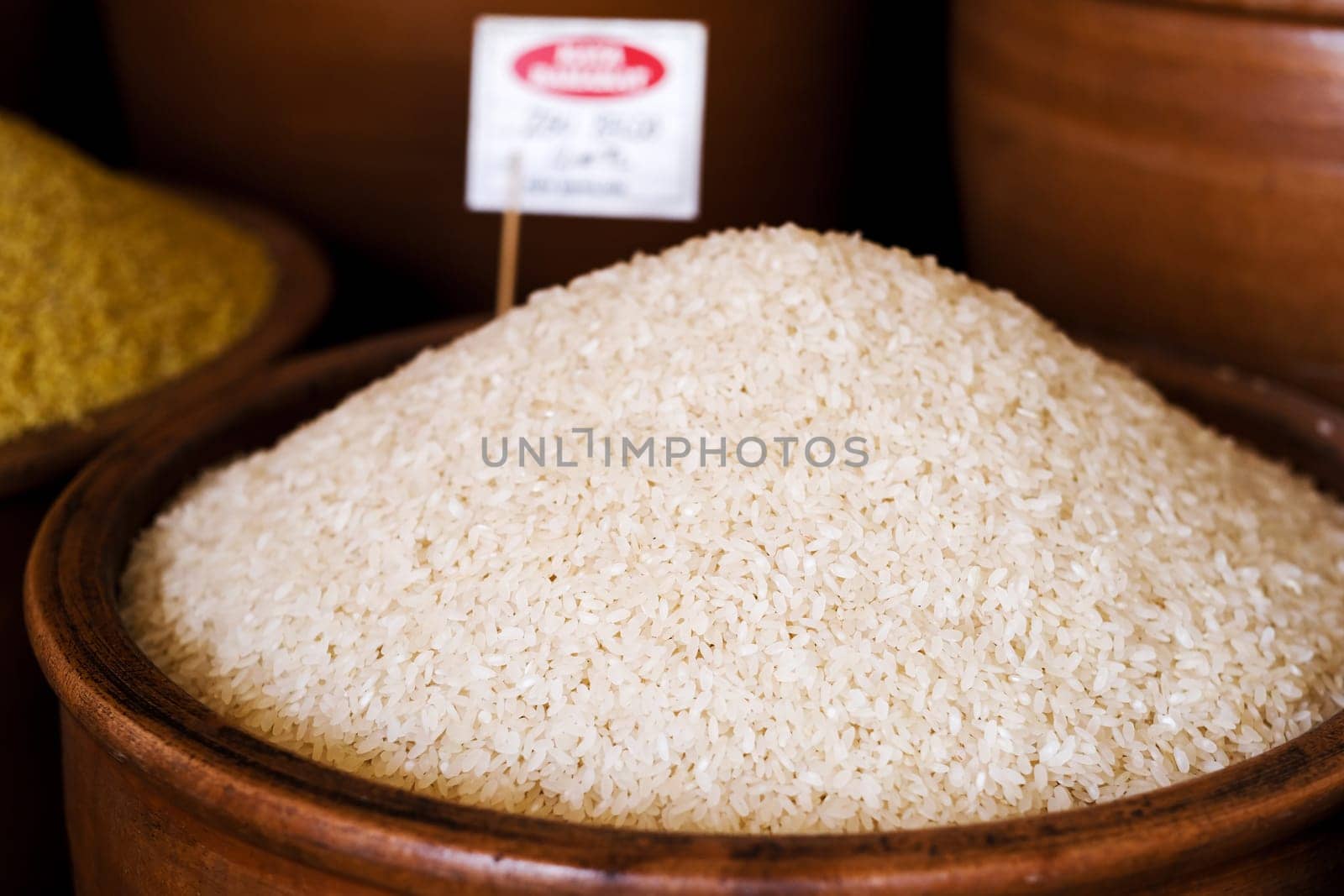 Pile of raw rice in bowl on market for sell