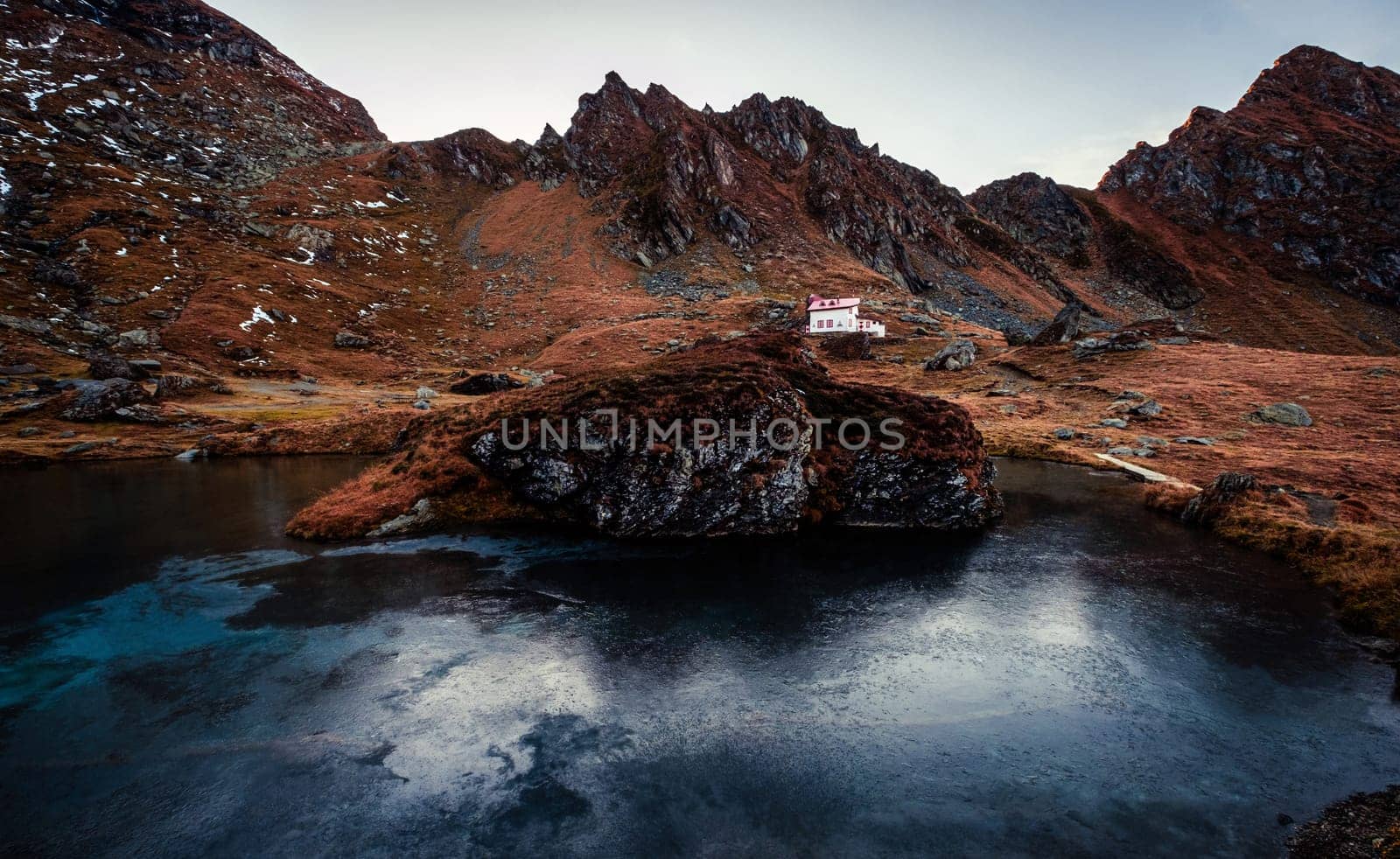 Scenic view of building near lake in mountains