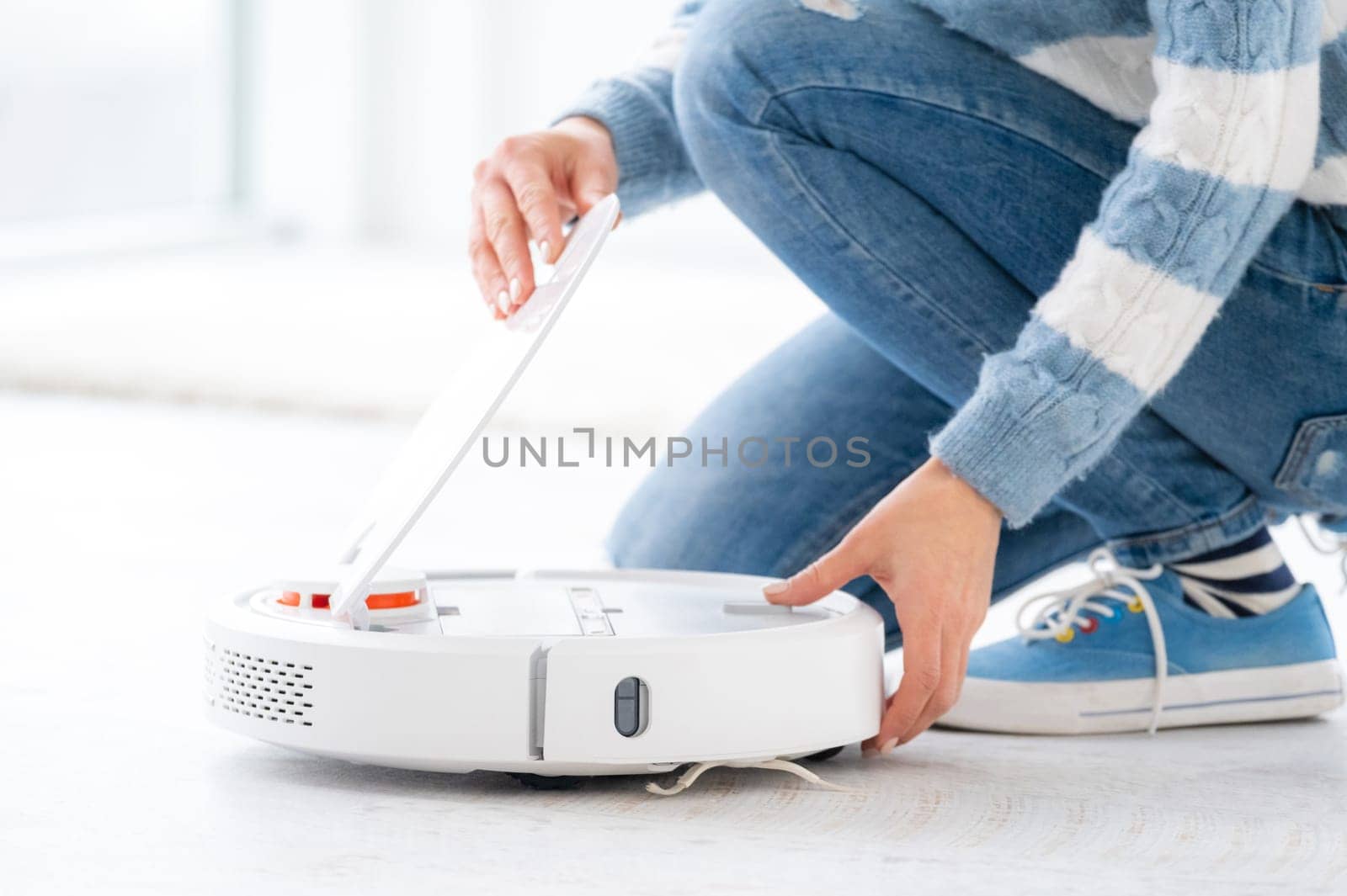 Woman with robotic hoover at home