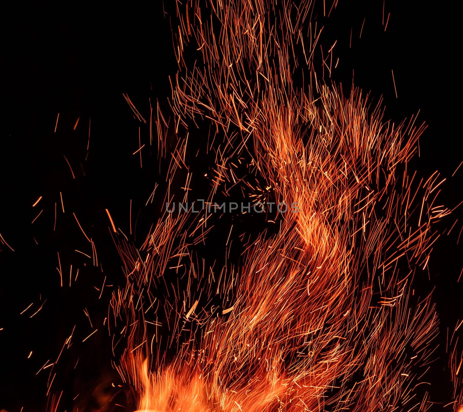 Scattering of sparks from fire on black background