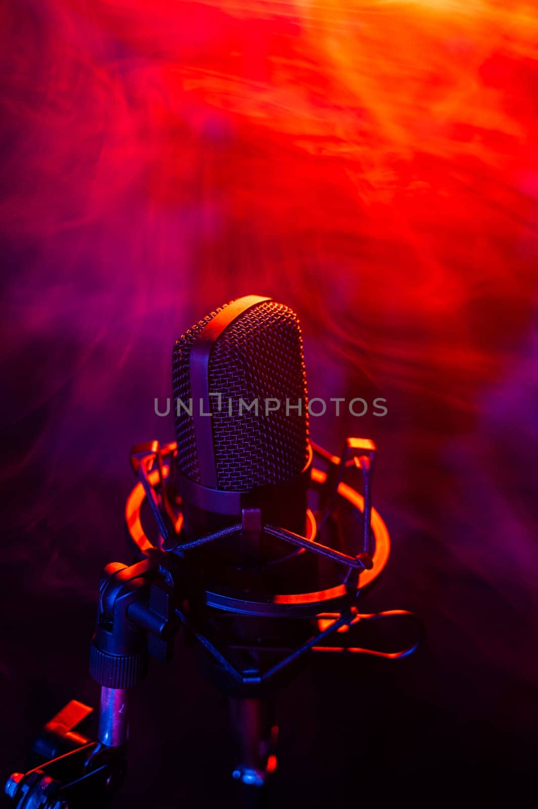 Professional microphone in red blue smoke on a black background