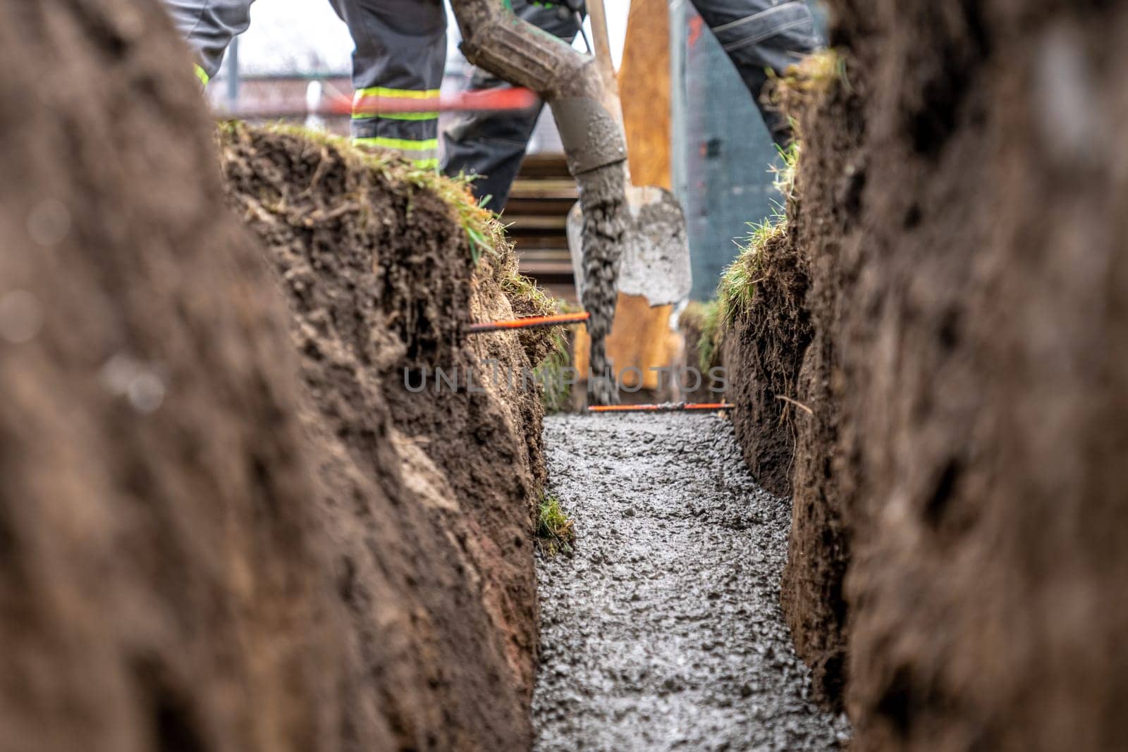 pour concrete from the mixer of the foundation of the building in the ground.