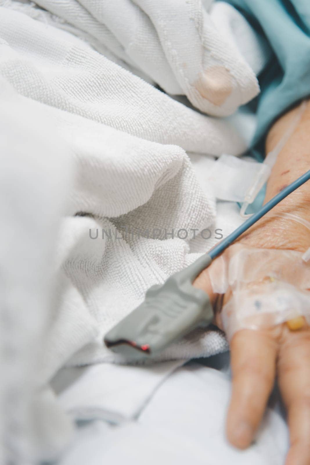 Patient asian elder woman 80s flu covid19 with pulse gauge for heartbeat measuring and blood pressure on a patient elderly finger on patient bed in intensive care unit (ICU.) room at hospital