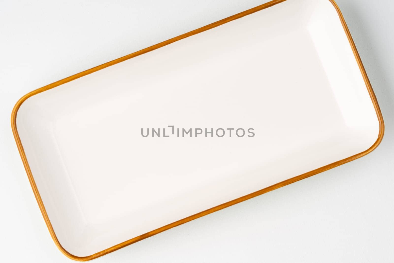 A white ceramic rectangular serving tray with an orange outline. Top view