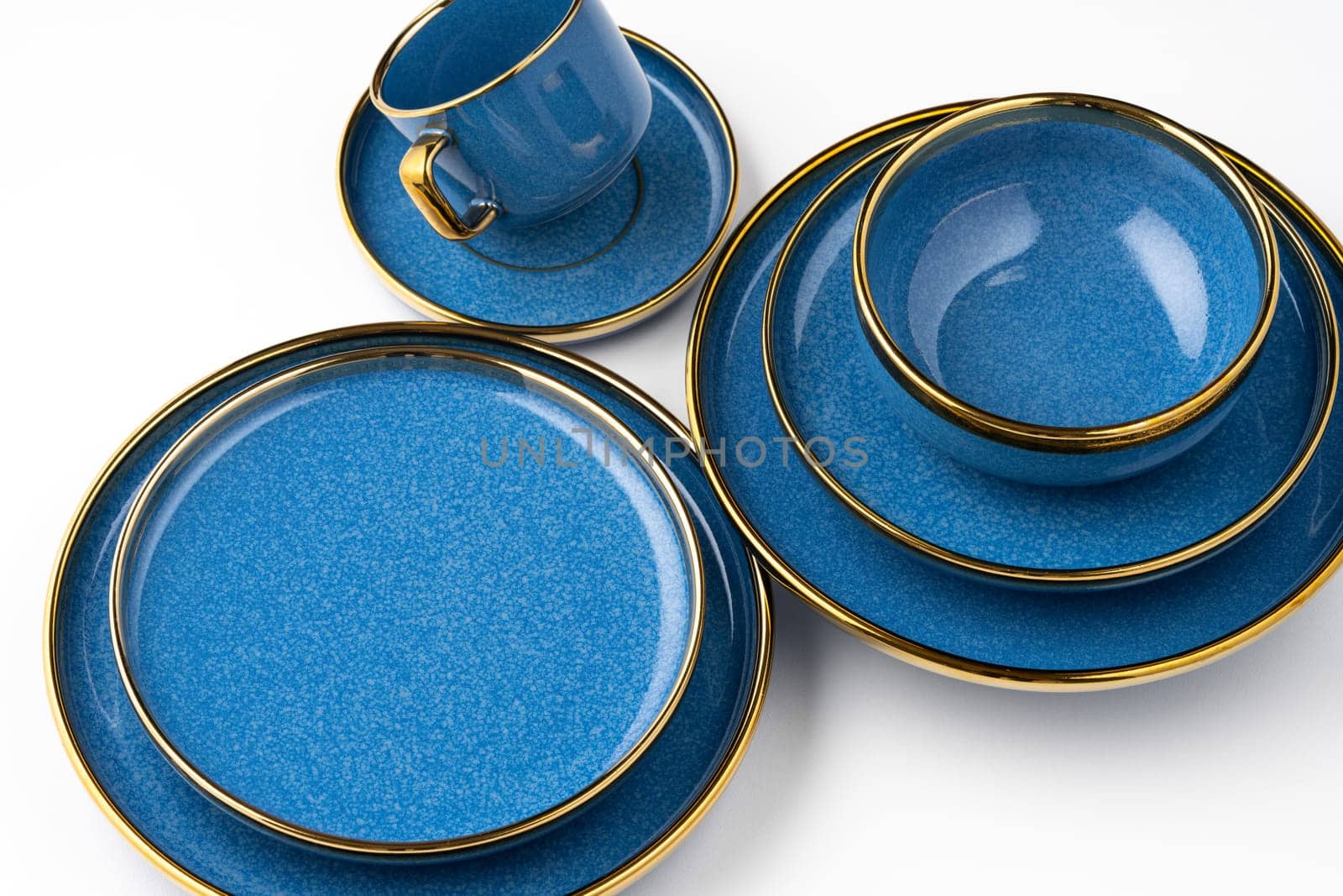 A set of blue ceramic plates and cup on a white background