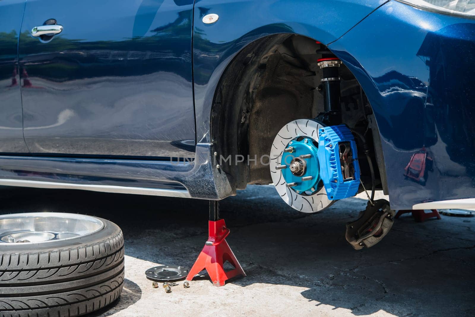 Checking car brake system for repair at car garage by PongMoji