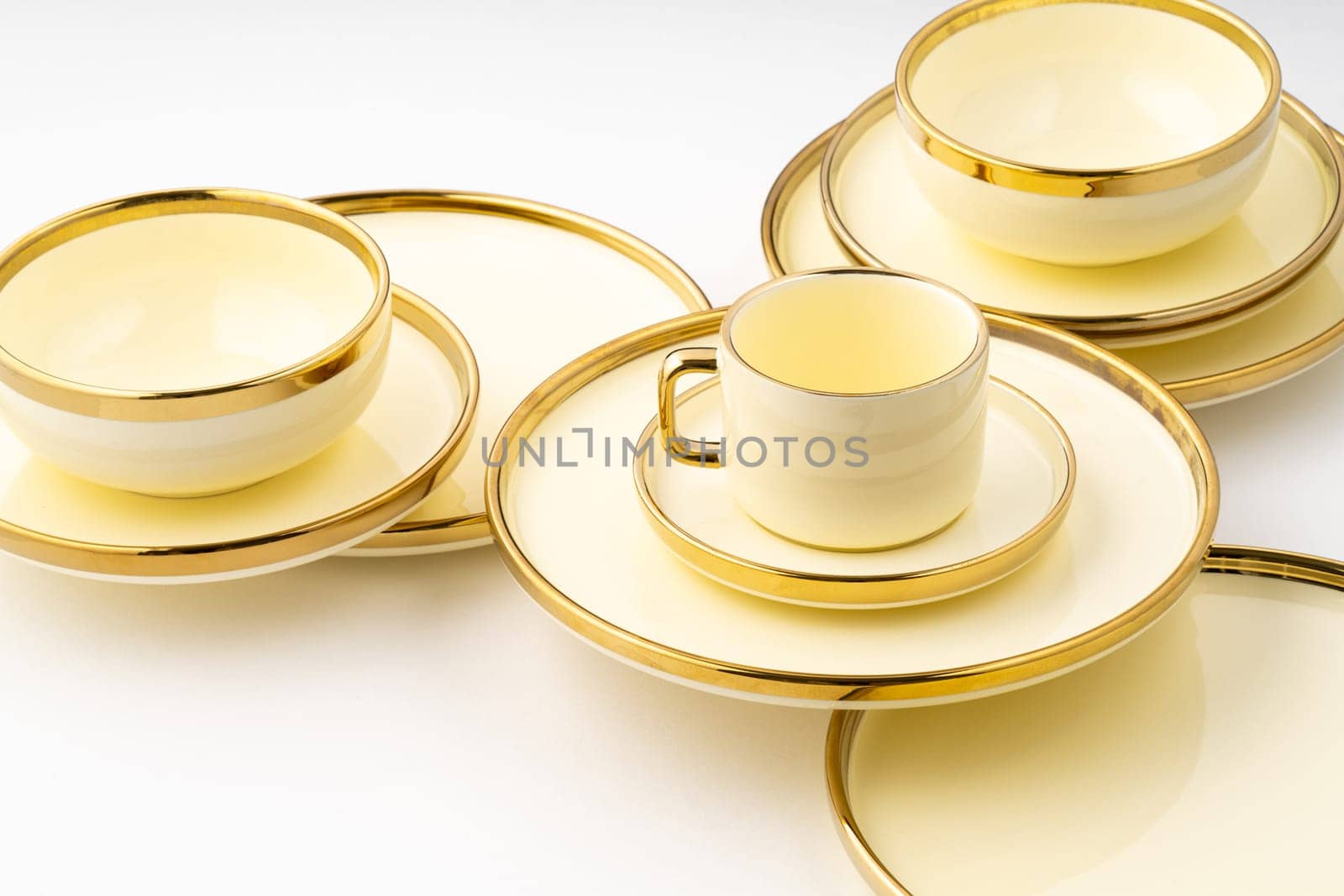 A set of golden luxury ceramic kitchen utensils on a white background
