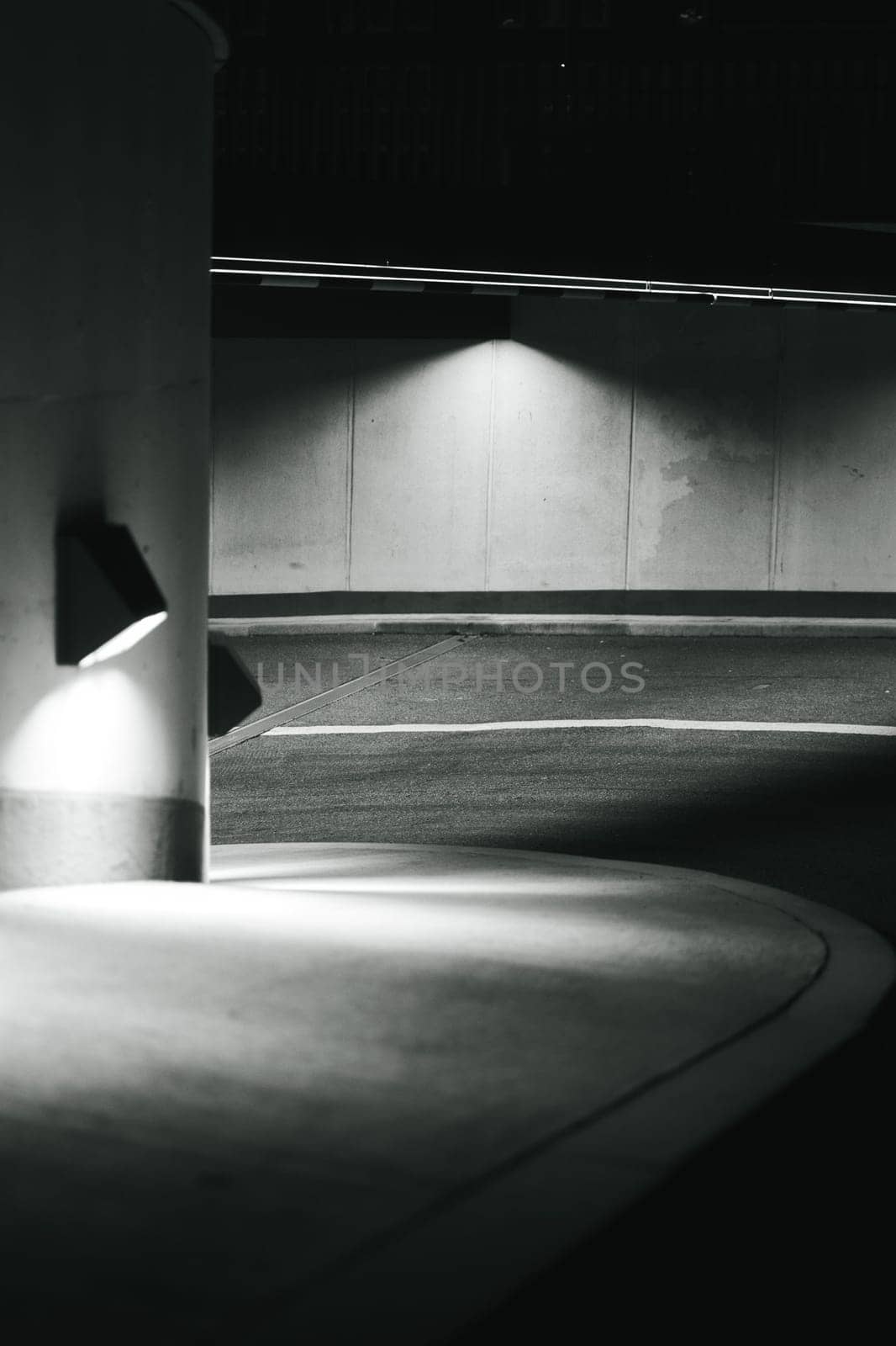 Vertical grayscale shot of the curved parking garage entrance in Duisburg, Germany.