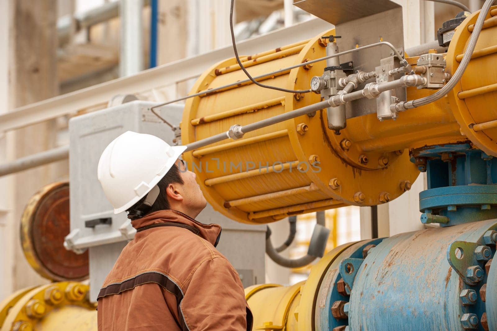 A close-up of a worker observing the indicators on an industrial pump. Oil and gas industry