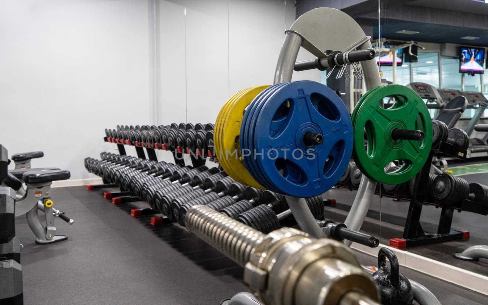 A closeup of weight plates and dumbbells in the sports complex
