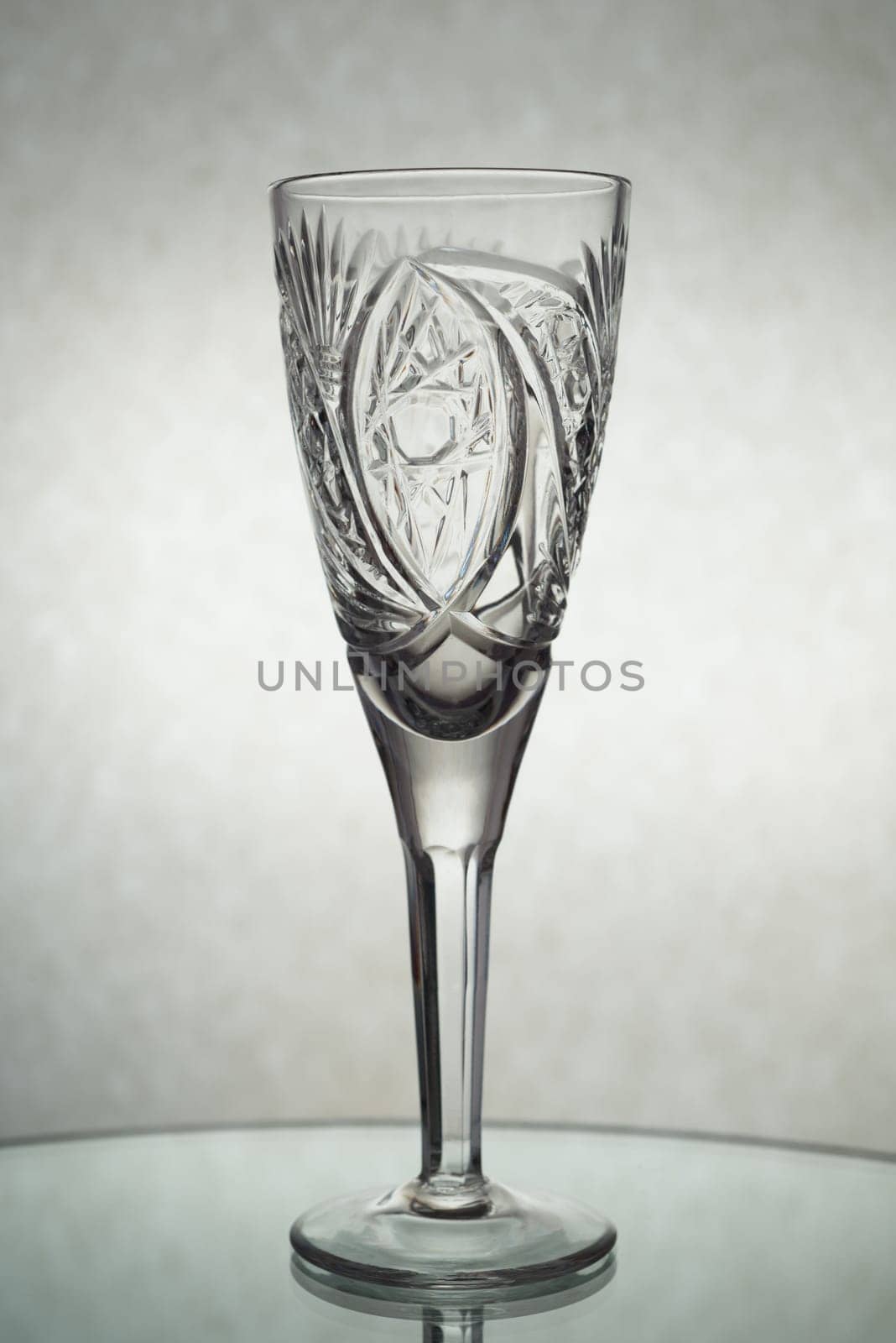 A vertical shot of an empty champagne glass on a grey background