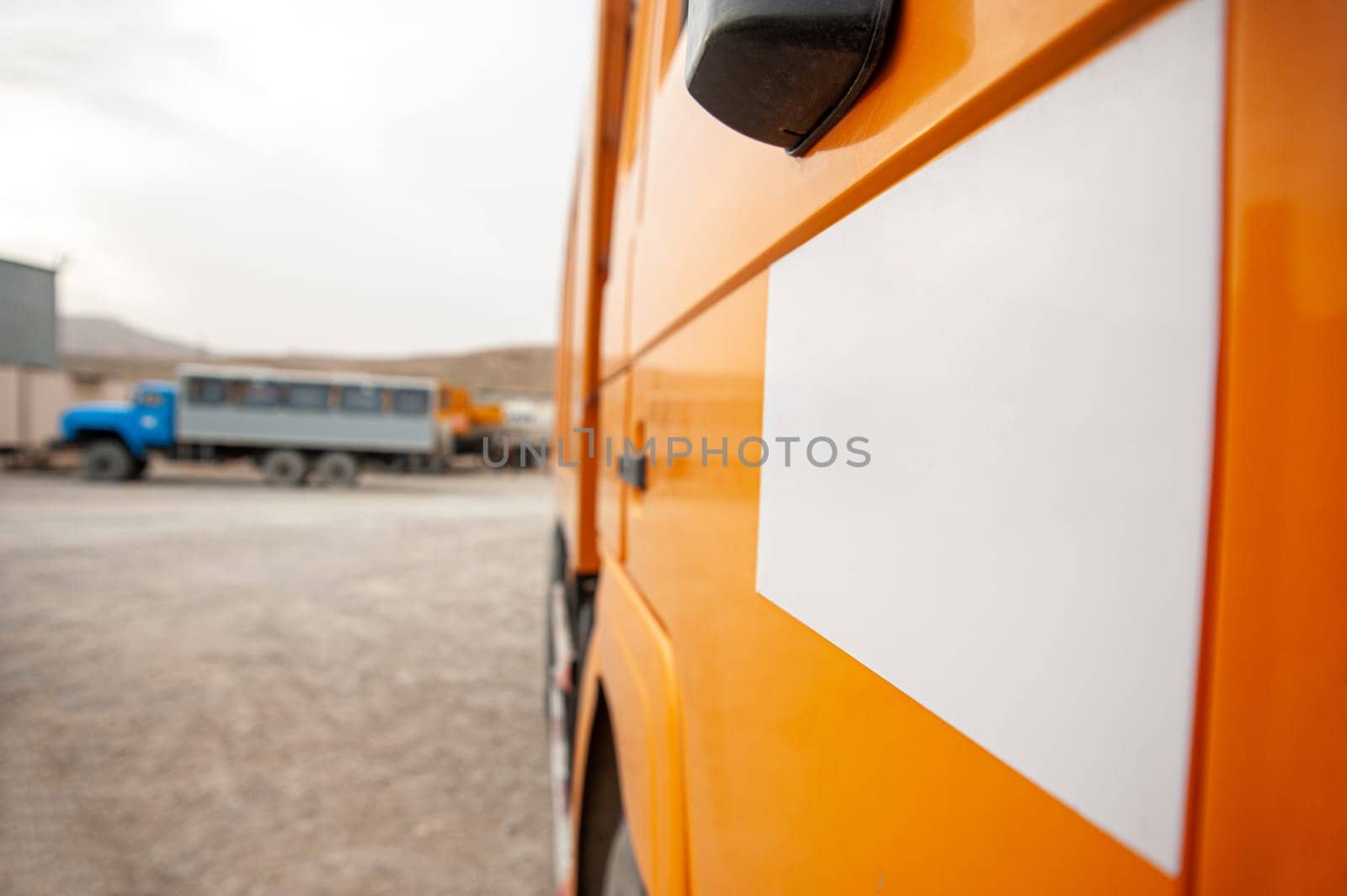 A closeup of an orange dump truck door at a construction site